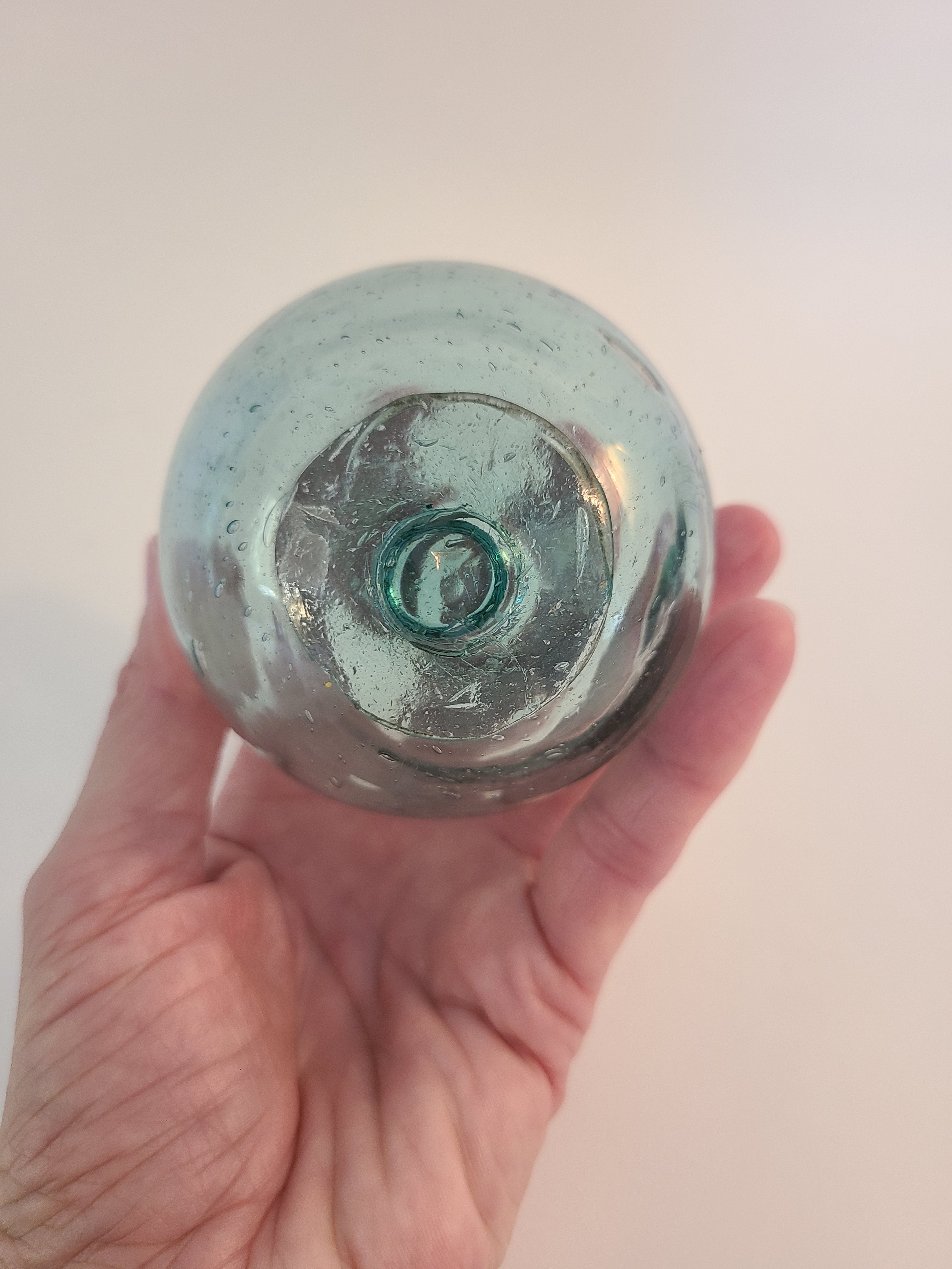 Authentic Glass Fishing Float 3" diameter in classic blue-green color held in person's hand.