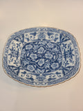A vintage rectangular blue and white porcelain serving platter featuring an intricate floral and vine pattern made in Japan.