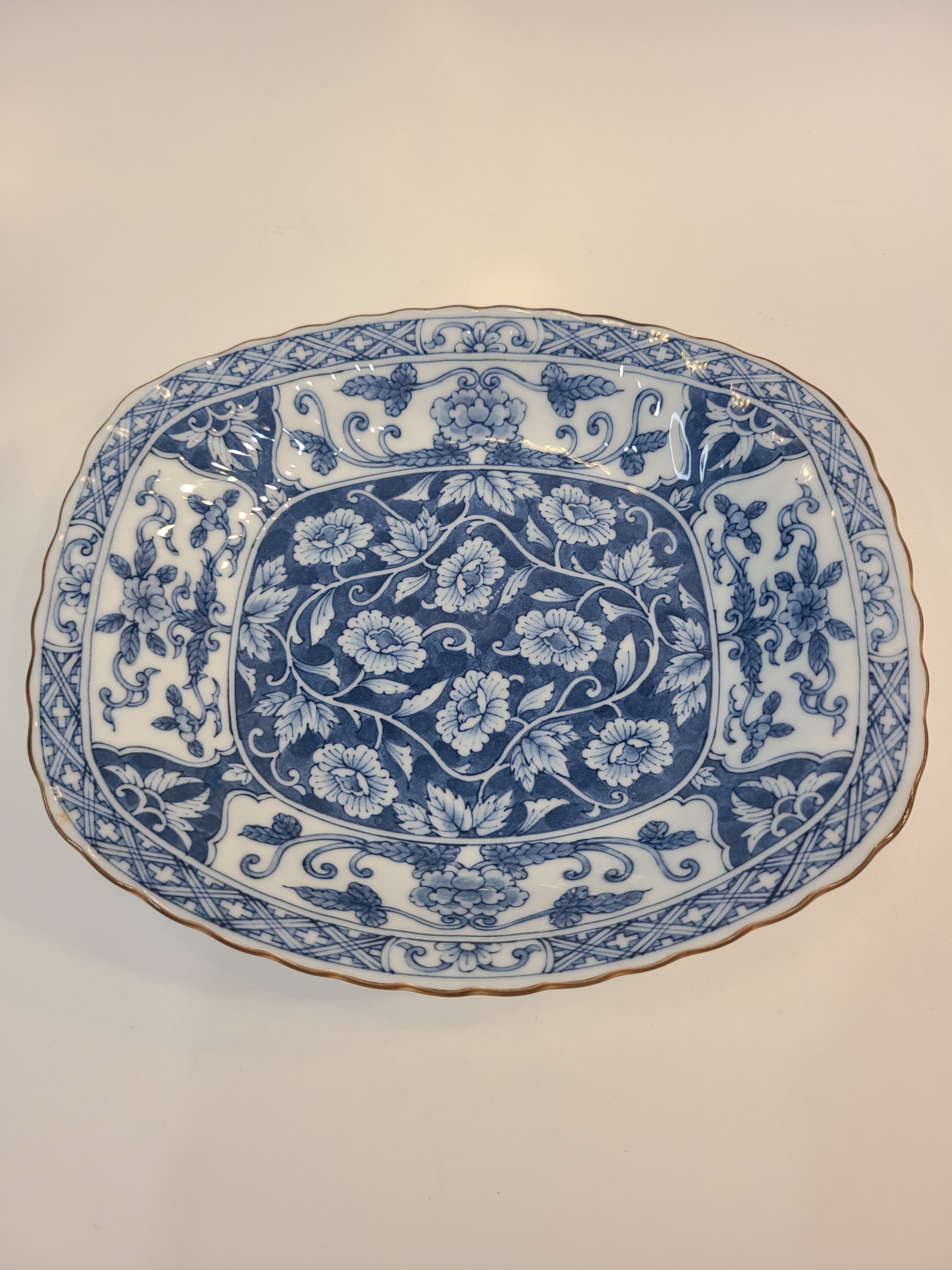 A vintage rectangular blue and white porcelain serving platter featuring an intricate floral and vine pattern made in Japan.