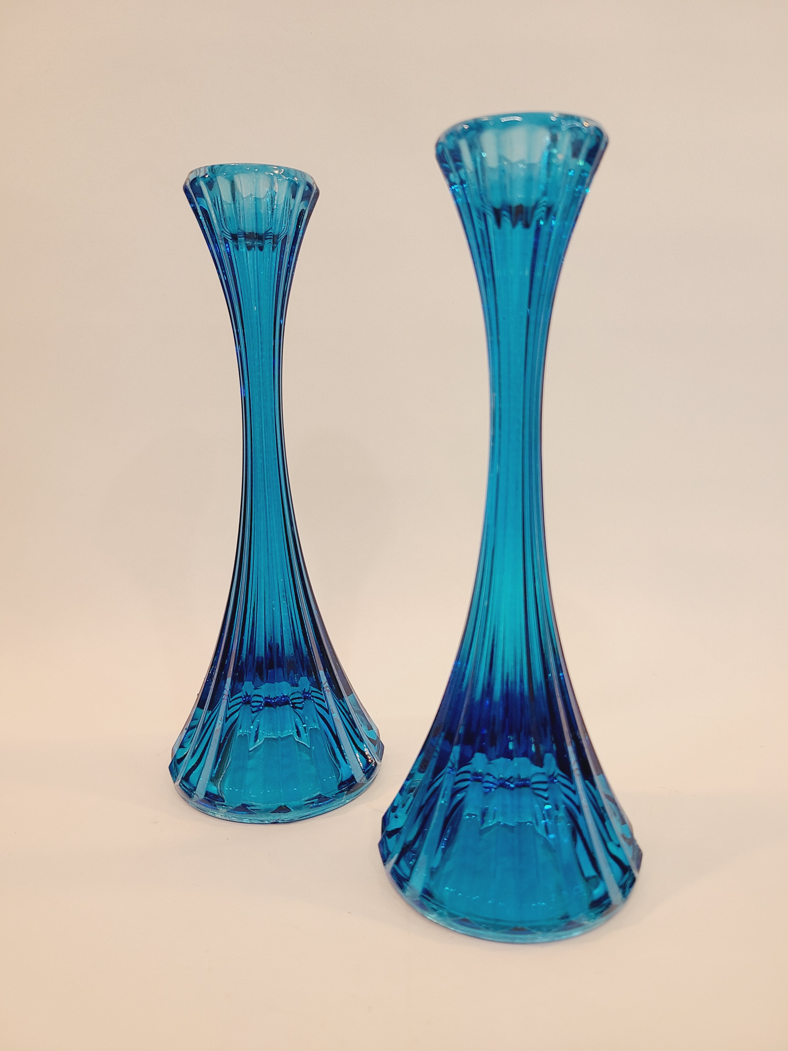 Pair of turquoise ridged glass candle holders, 1970s, 8 inches high, likely made in USA, on a light surface.