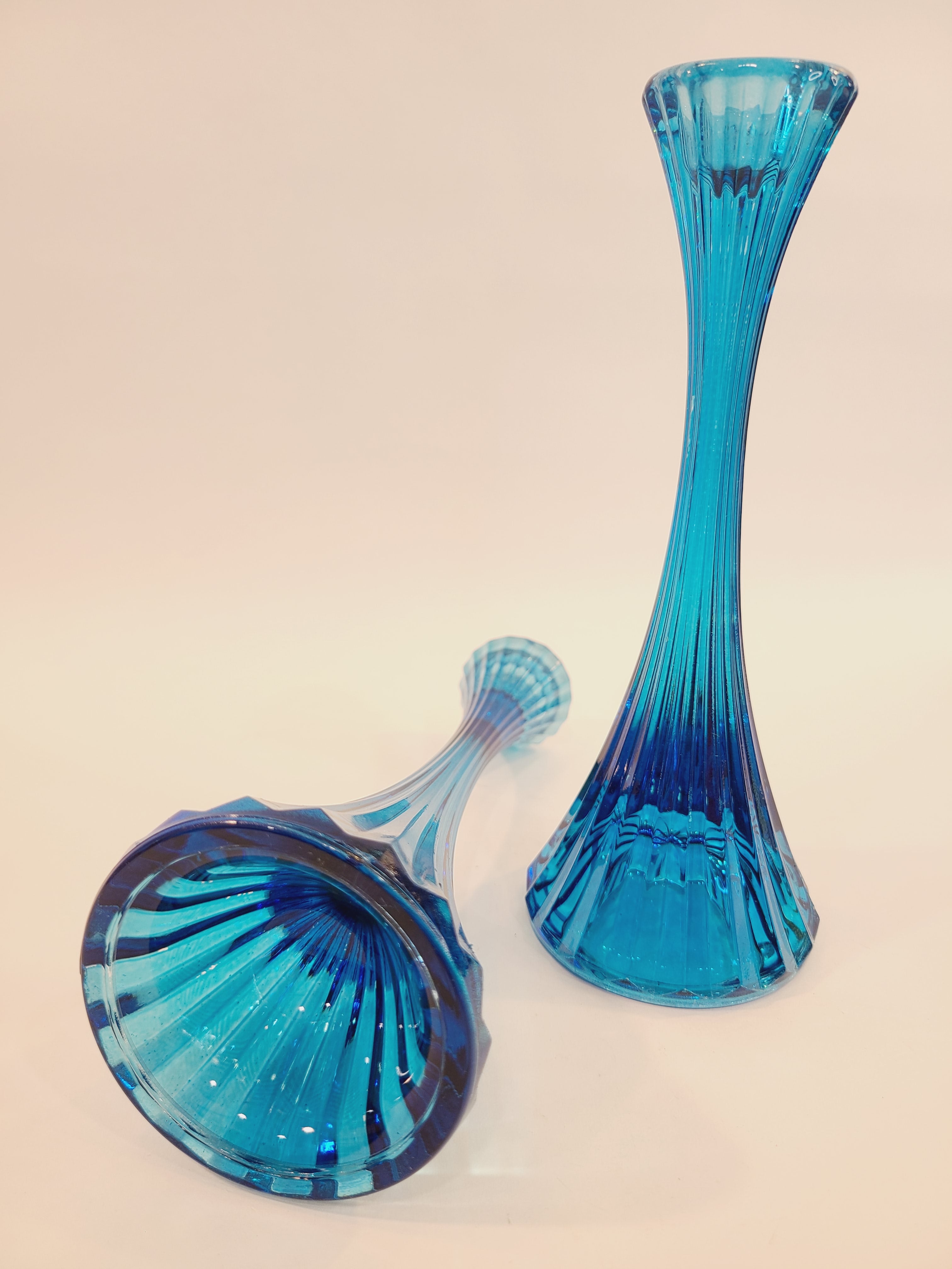 Pair of turquoise ridged glass candle holders, 1970s, 8 inches high, likely made in USA, one laying down the other upright.