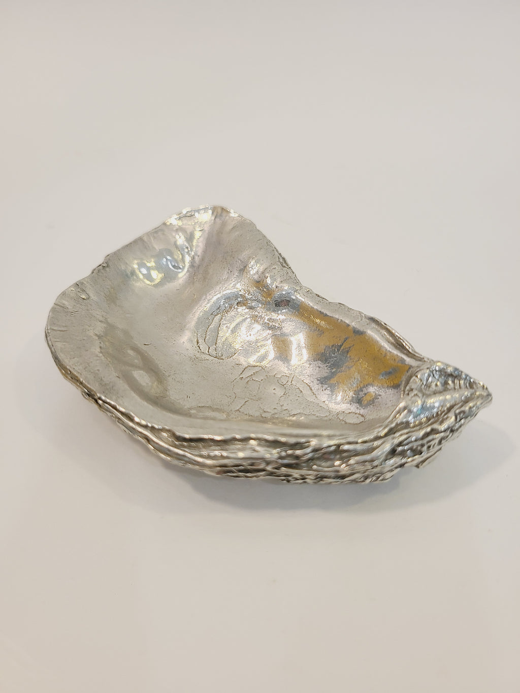 Pewter oyster shell dish, 3.75 inches by 2.25 inches on white background.