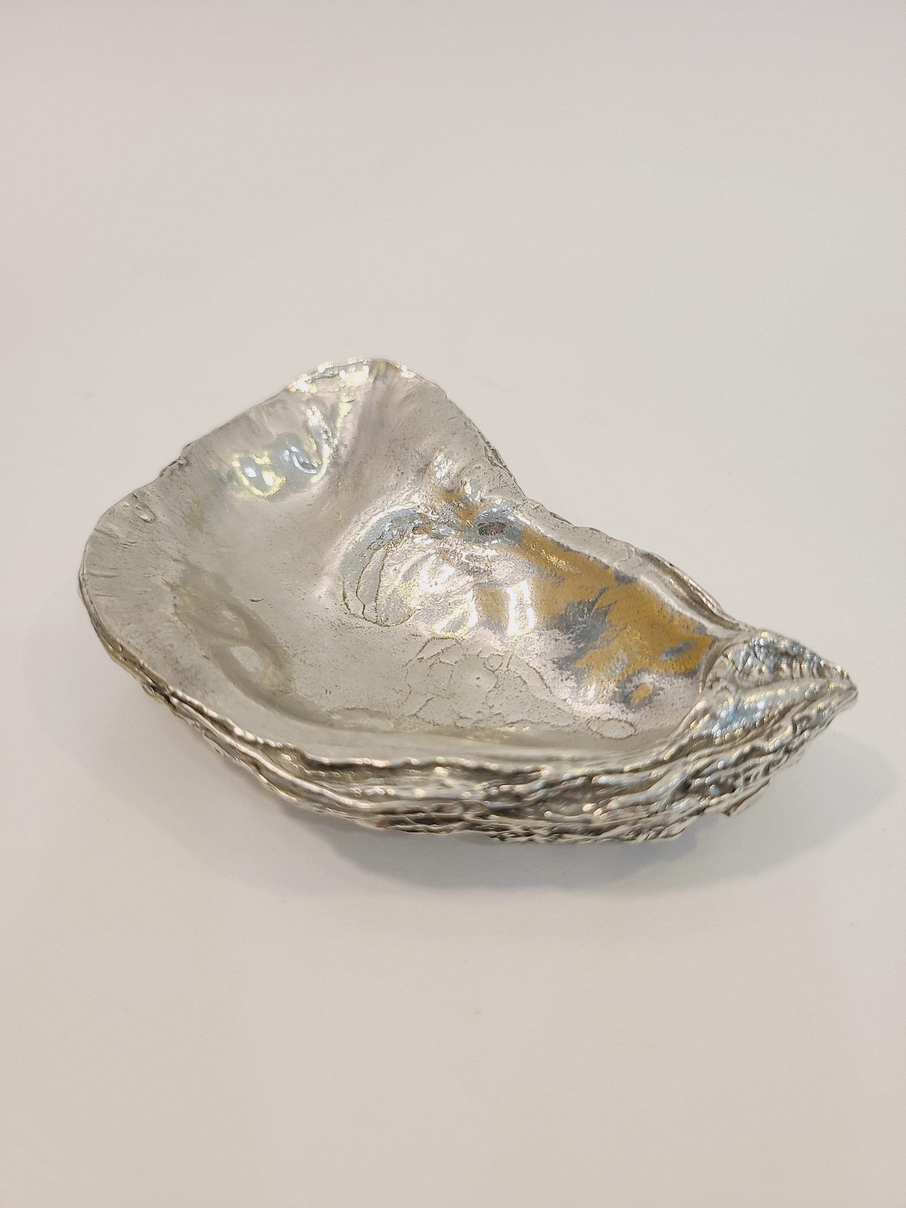 Pewter oyster shell dish, 3.75 inches by 2.25 inches on white background.