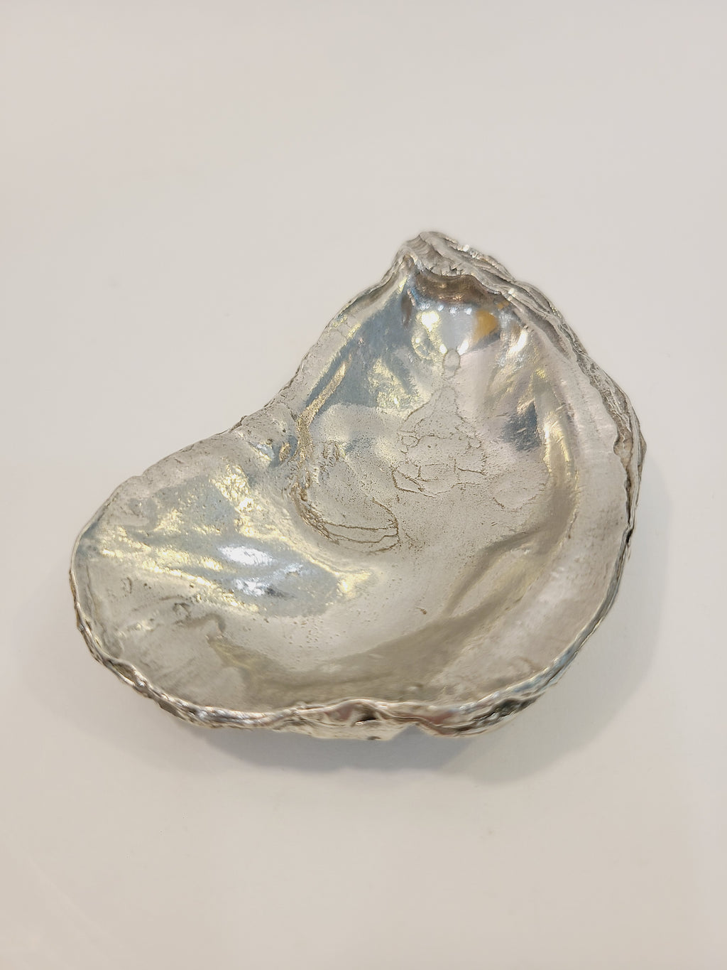 Pewter oyster shell dish, 3.75 inches by 2.25 inches highlight interior.