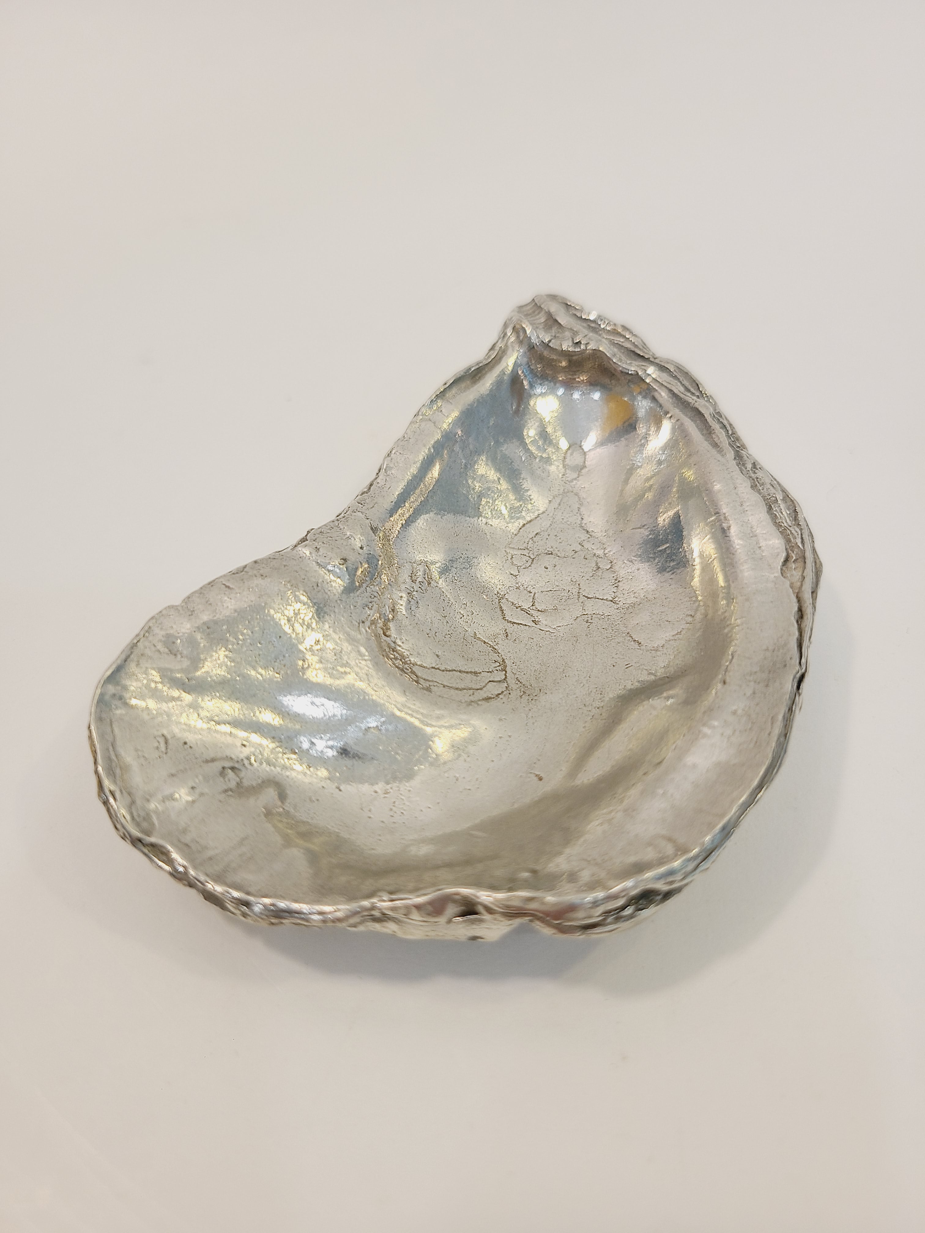 Pewter oyster shell dish, 3.75 inches by 2.25 inches highlight interior.