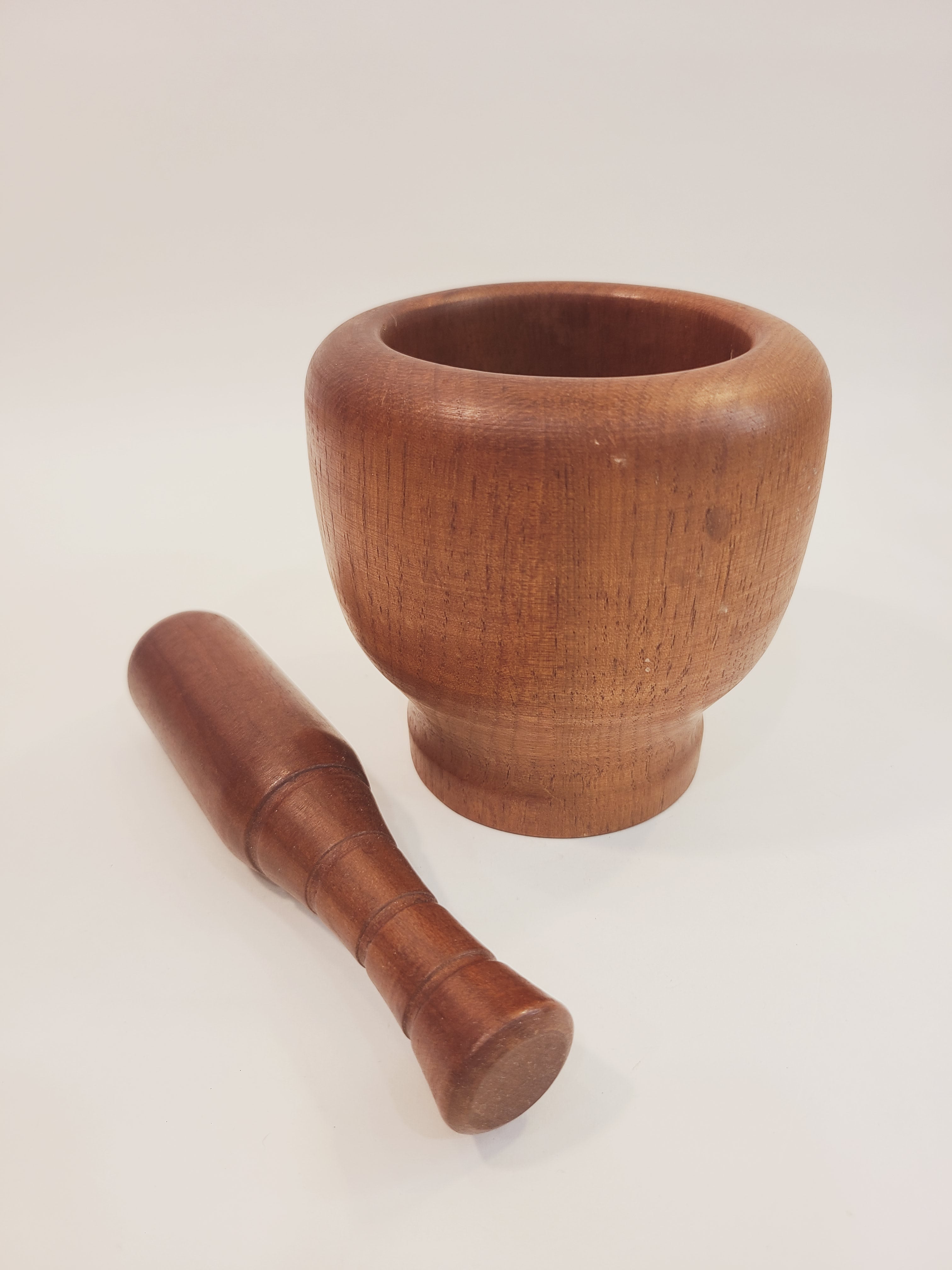 Antique Turned Wood Mortar and Pestle, Mortar 4.25 inches high by 4.25 inches diameter; Pestle 6 inches high, shown with pestle laying next to mortar with light background.