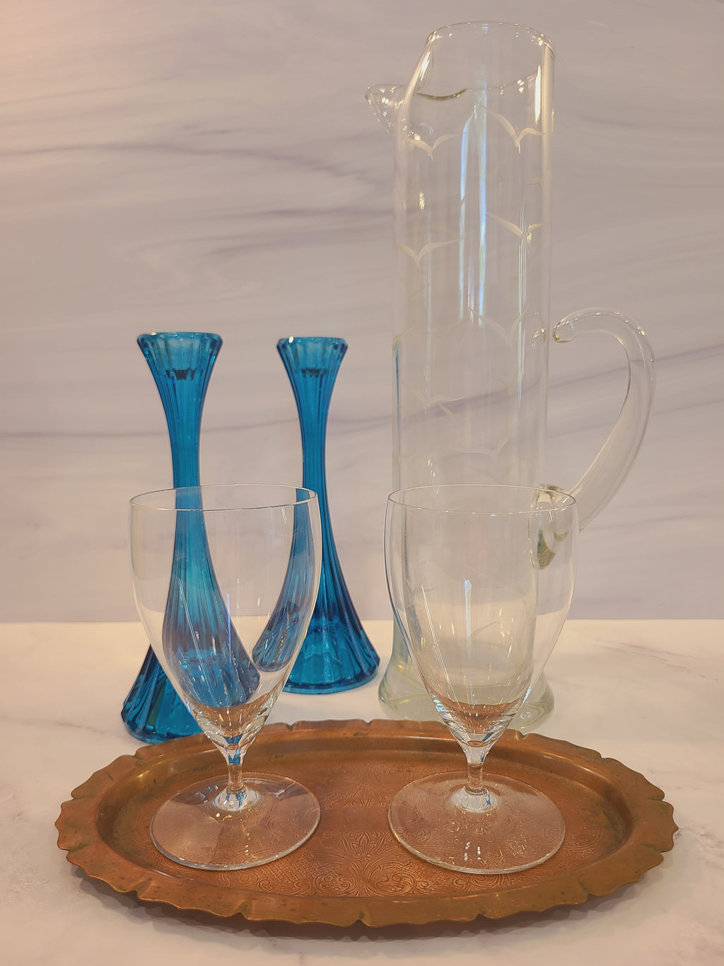 Pair of turquoise ridged glass candle holders, 1970s, 8 inches high, likely made in USA, displayed with clear glasses on a copper tray and clear glass pitcher.