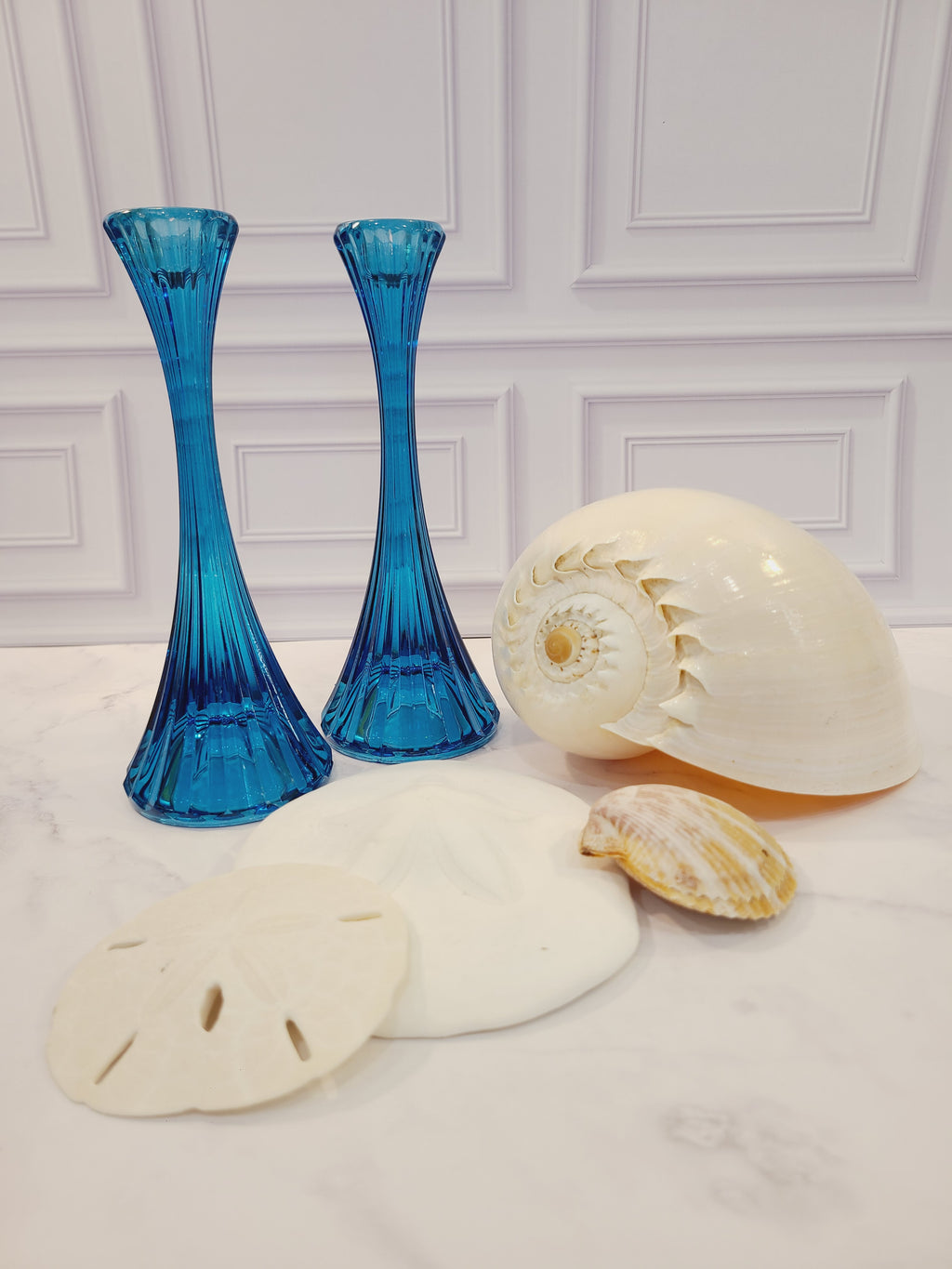 Pair of turquoise ridged glass candle holders, 1970s, 8 inches high, likely made in USA, displayed seashells on light background.