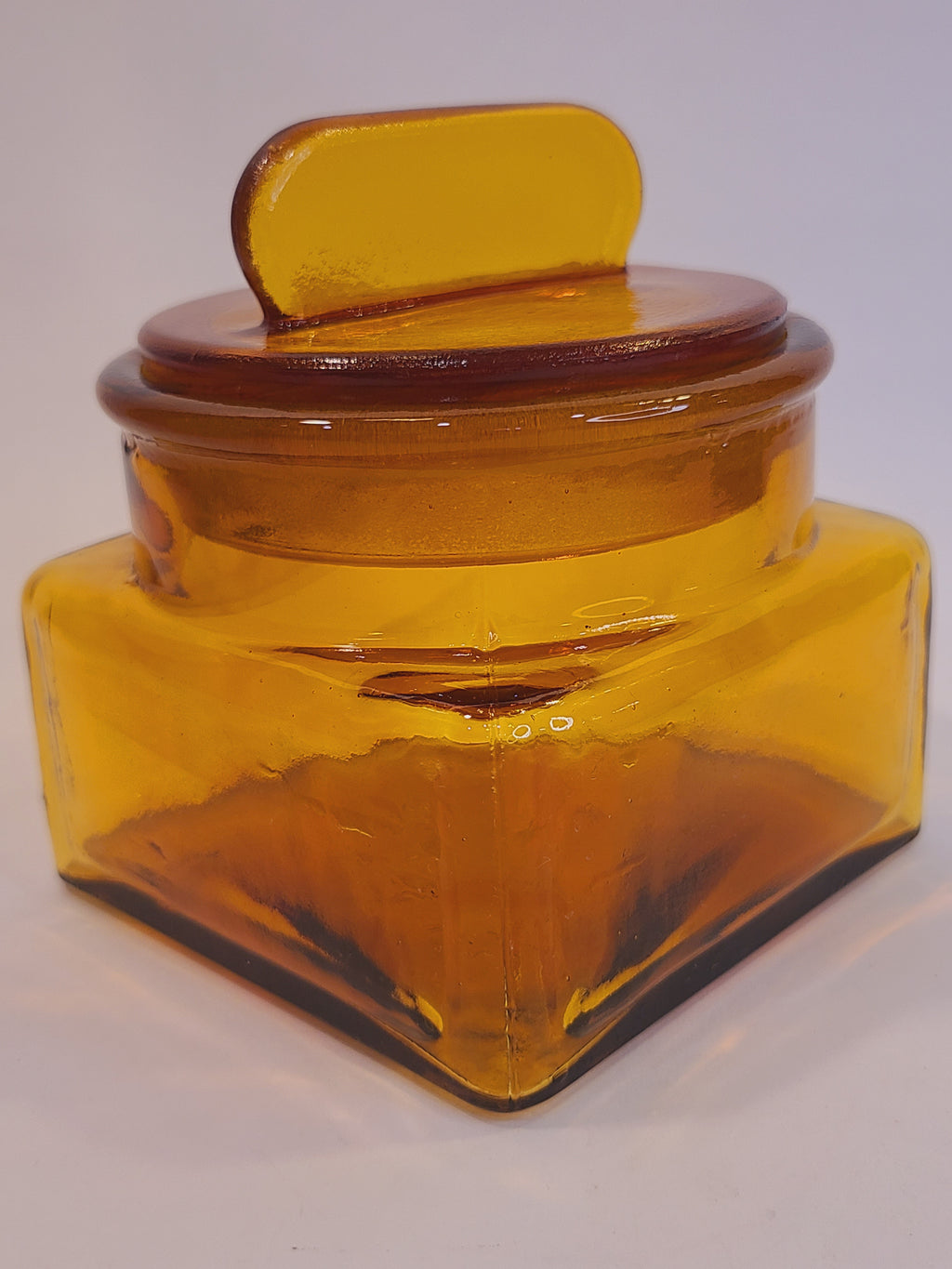 Angle view of Antique Dakota Square Amber Glass Apothecary Jar 1890s with lid
