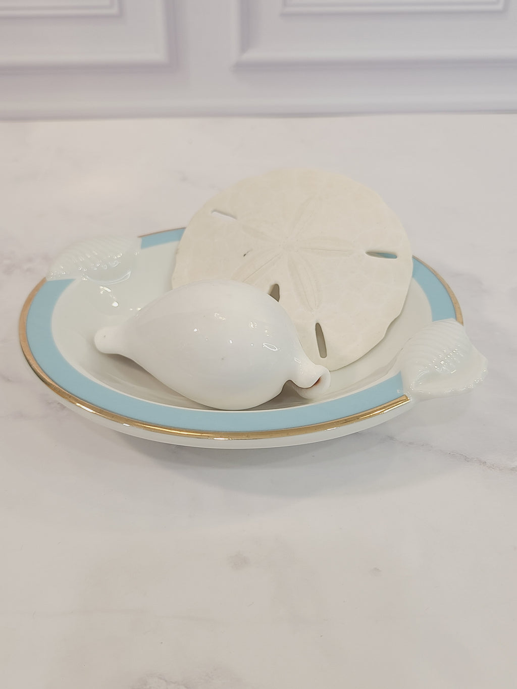 Top view of Ben Rickert Fine China Dish with Seashell Embossed Rim and aqua and gold trim 1980s shown with shells