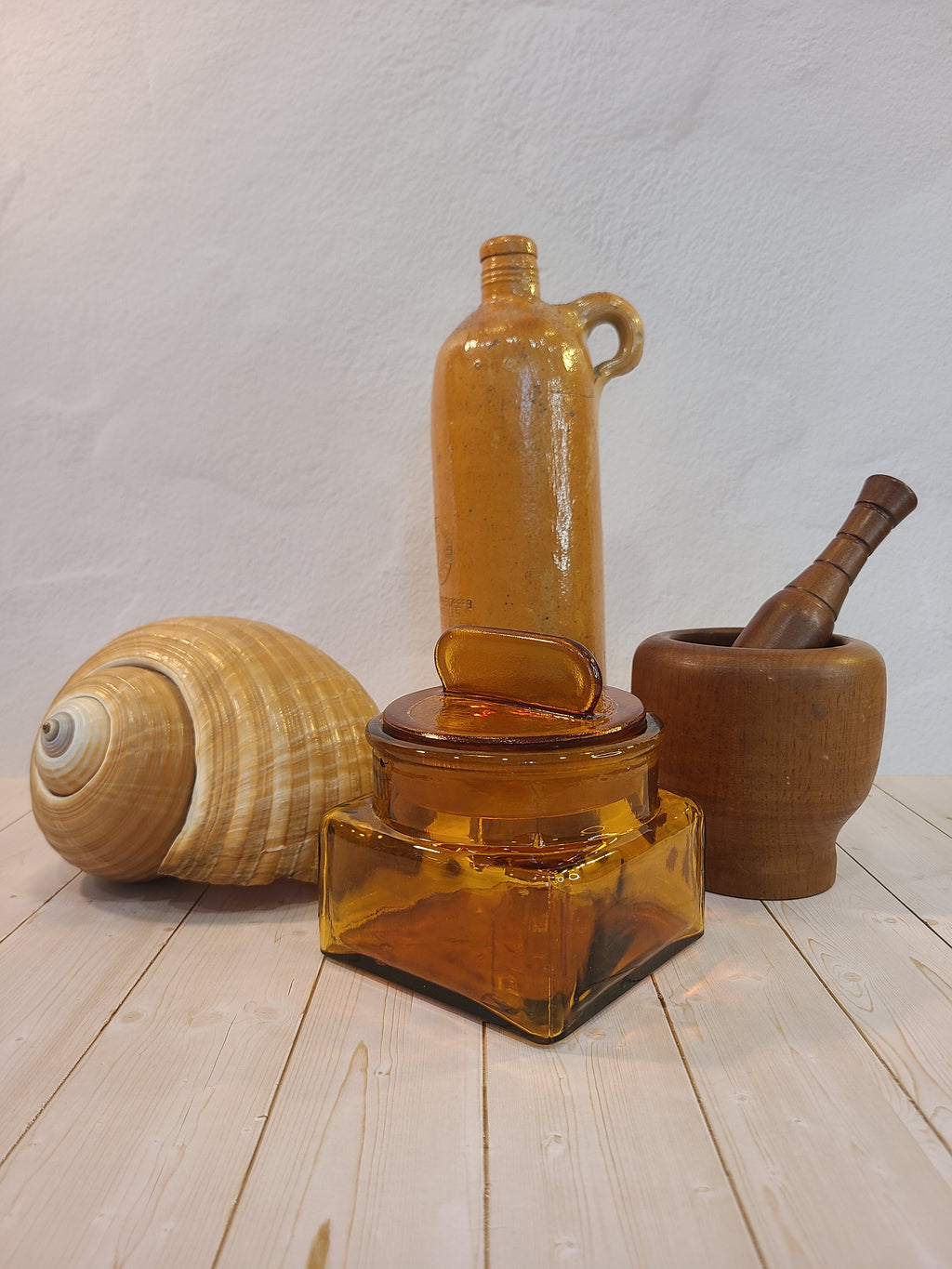 Antique Dakota Square Amber Glass Apothecary Jar 1890s with lid shown with shell, wood mortar and pestle and ceramic bottle