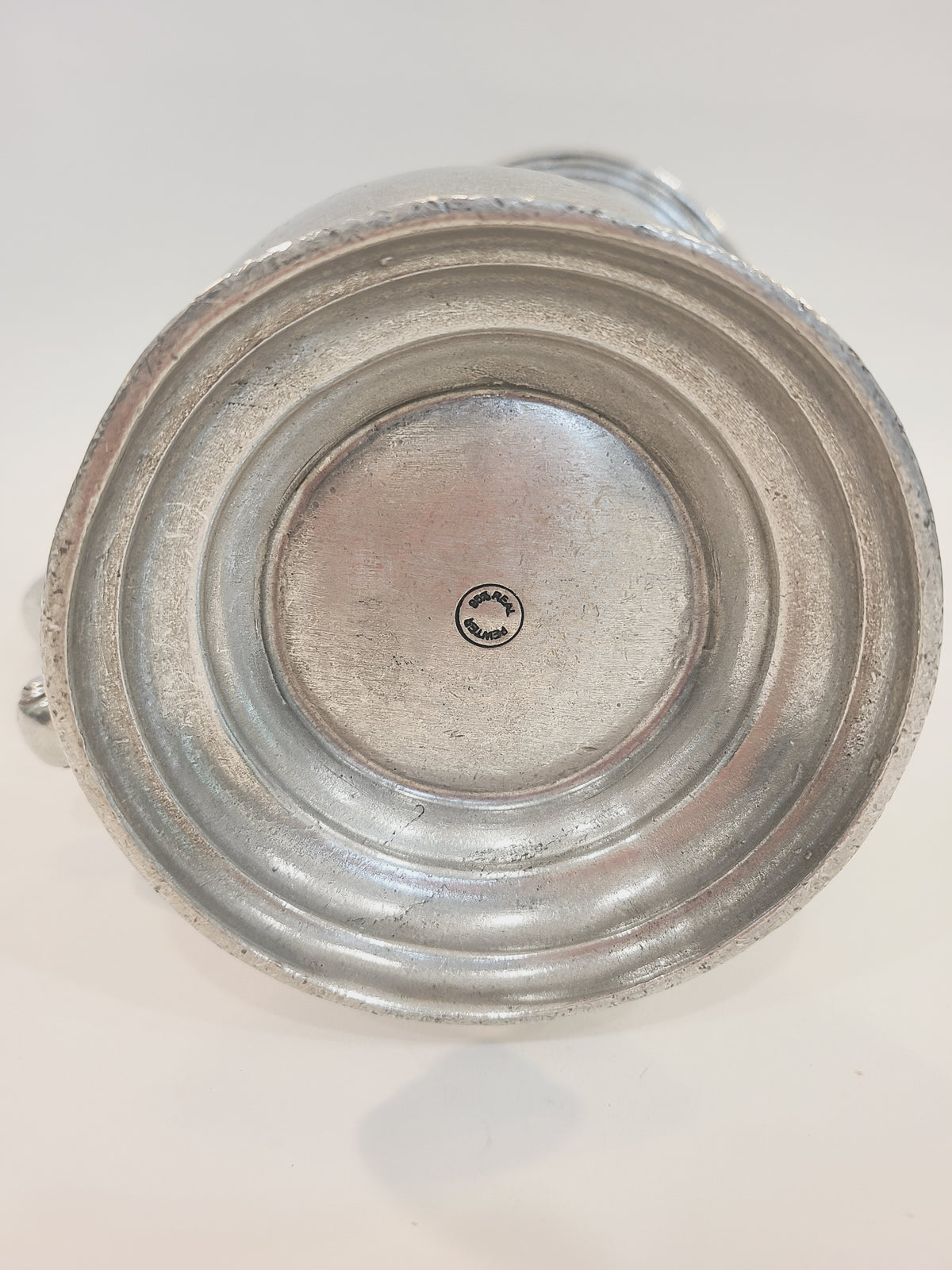 Base of vintage pewter pitcher showing circular 95% Real Pewter hallmark stamp, authentication detail of lead-free food-safe alloy