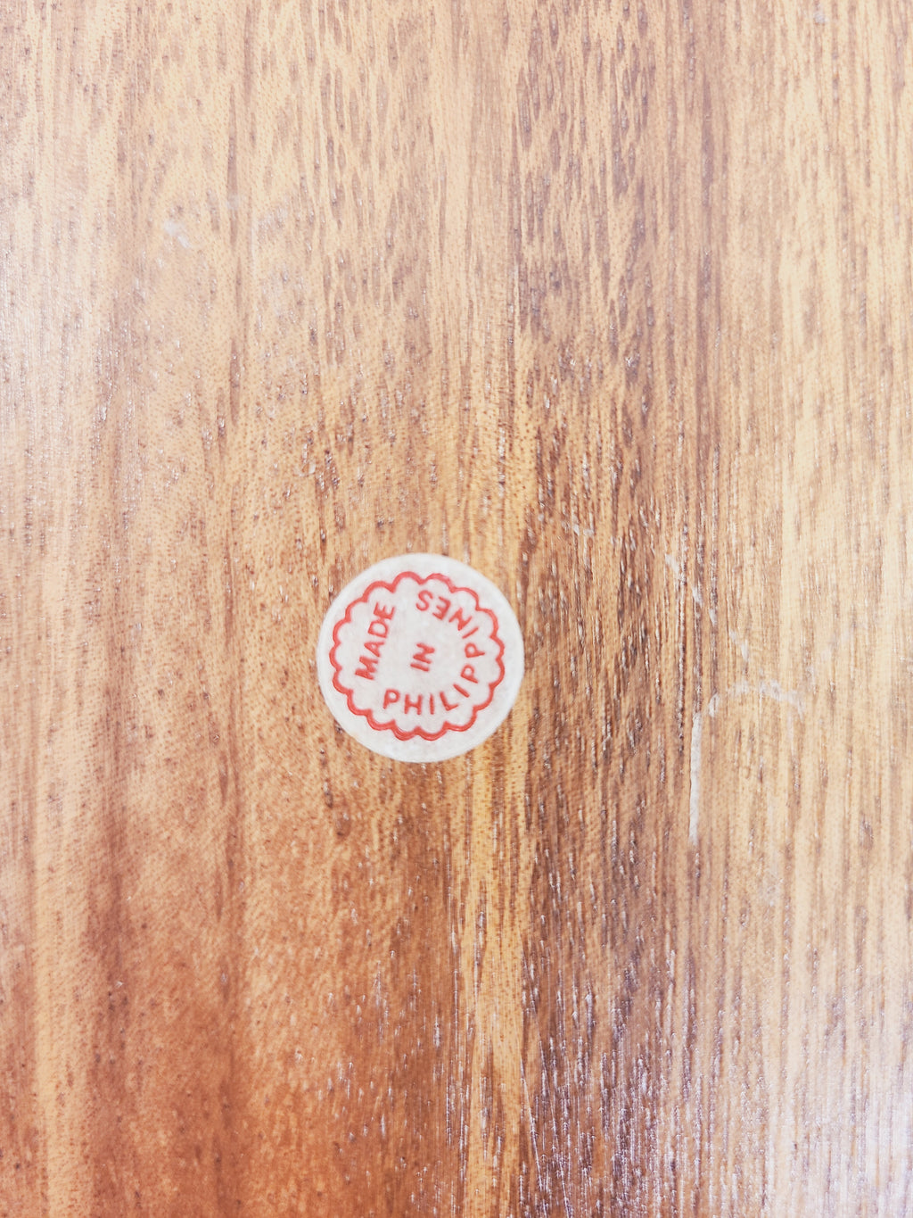 Close-up of original Made in Philippines paper label on monkey pod wood tray, provenance detail of authentic 1950s–1960s Philippine handcraft
