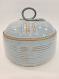 Pat Look signed studio pottery covered bowl in pale blue glaze with natural clay reveal at rim, hand-thrown stoneware, American craft movement late 20th century