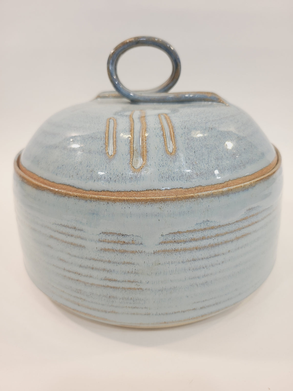 Pat Look signed studio pottery covered bowl in pale blue glaze with natural clay reveal at rim, hand-thrown stoneware, American craft movement late 20th century