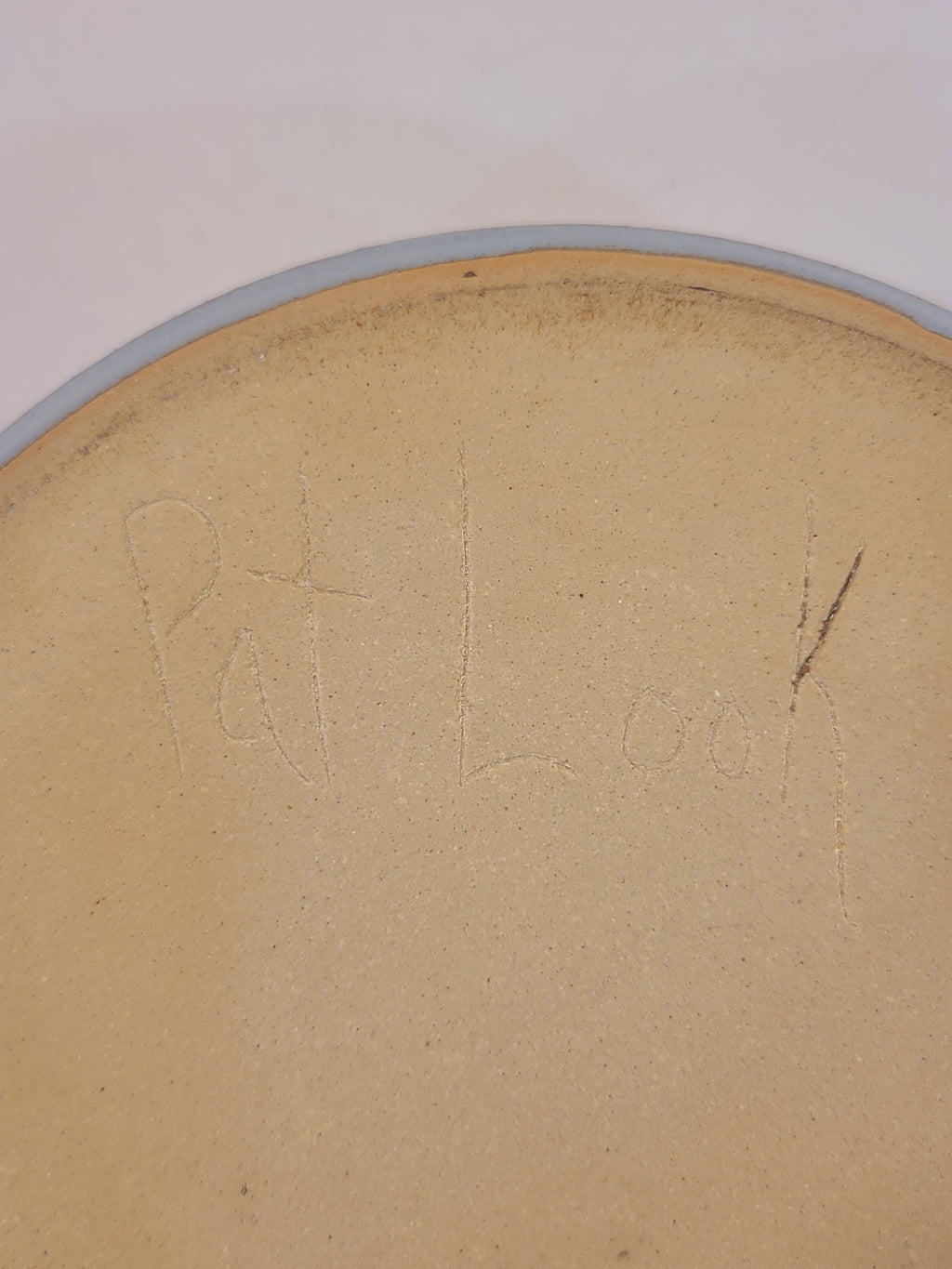 Underside of Pat Look studio pottery bowl showing hand-incised artist signature in natural stoneware clay, authentication detail of signed American studio pottery