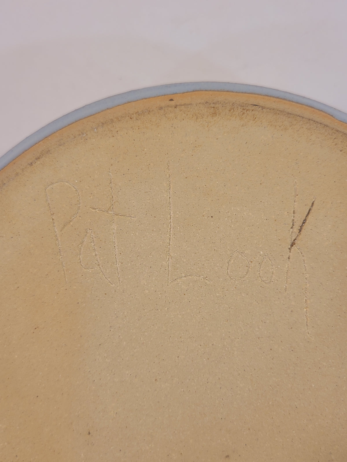Underside of Pat Look studio pottery bowl showing hand-incised artist signature in natural stoneware clay, authentication detail of signed American studio pottery