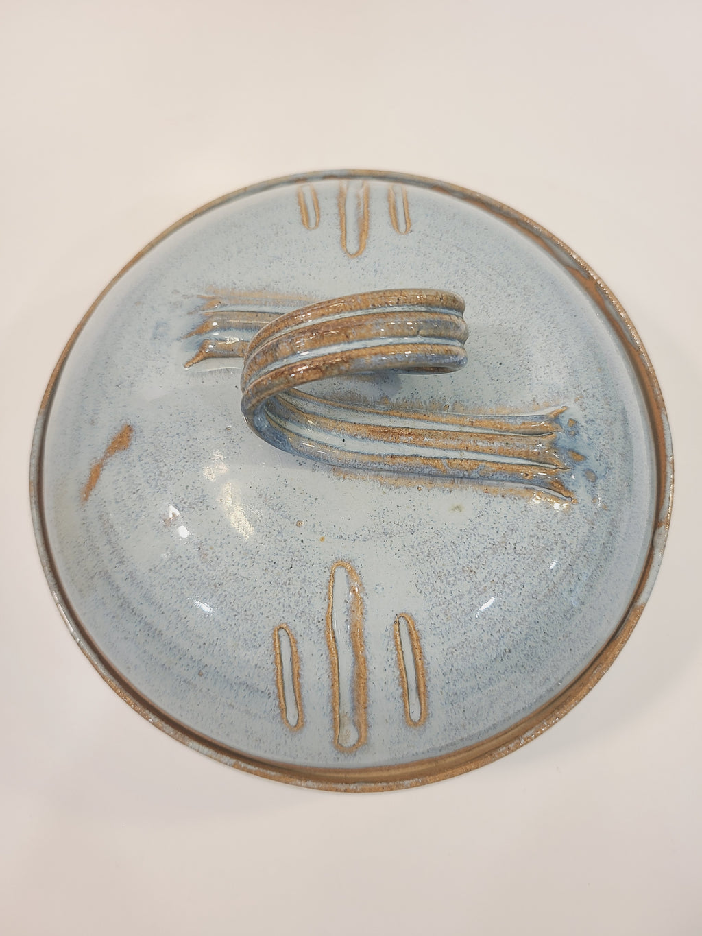 Overhead view of Pat Look studio pottery lid showing loop handle and incised decorative marks on pale blue speckled glaze, signed American studio craft