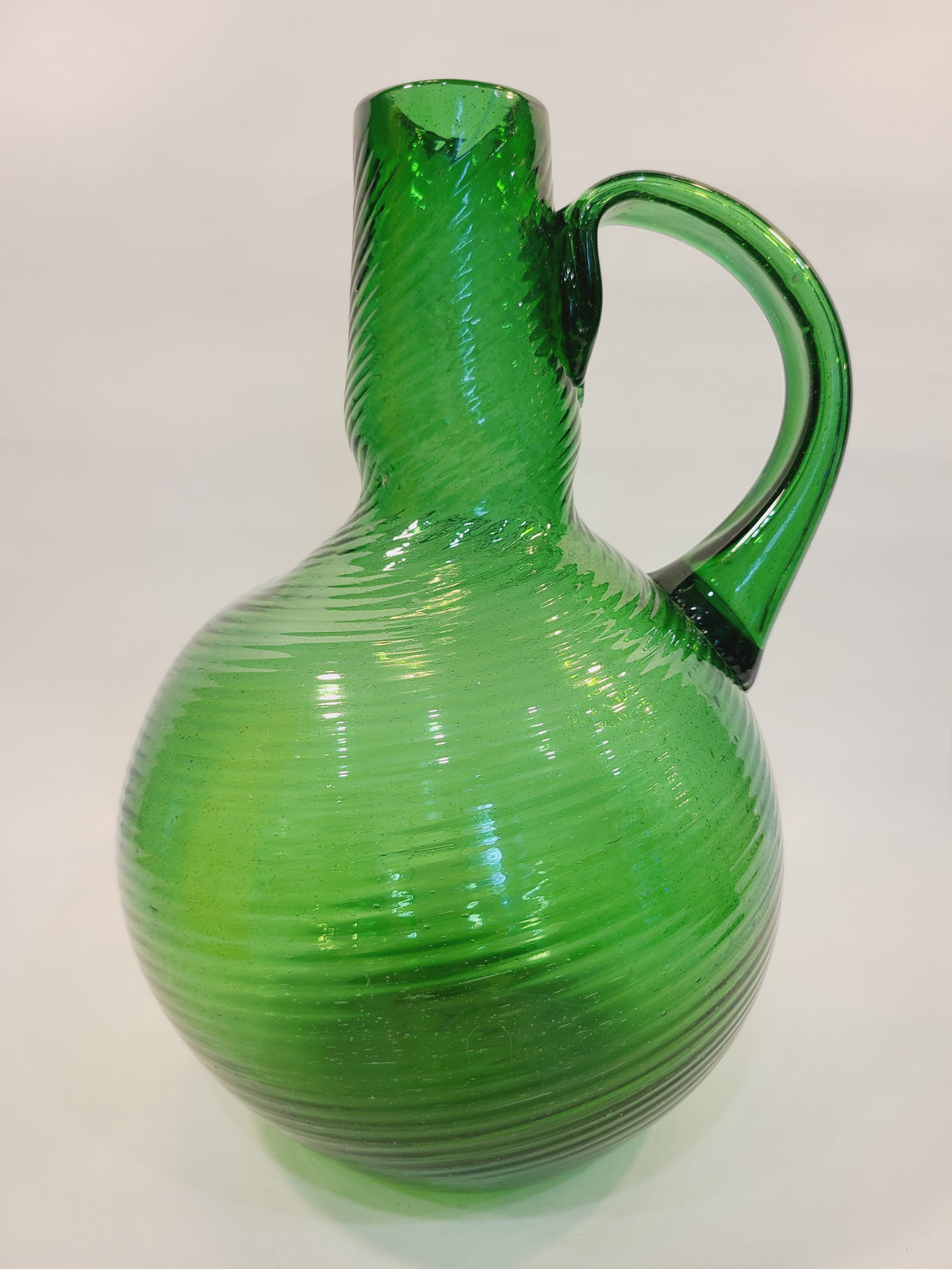 Emerald green handblown art glass jug vase with spiral swirl texture and applied handle, circa 1950s–1960s, 12 inches tall