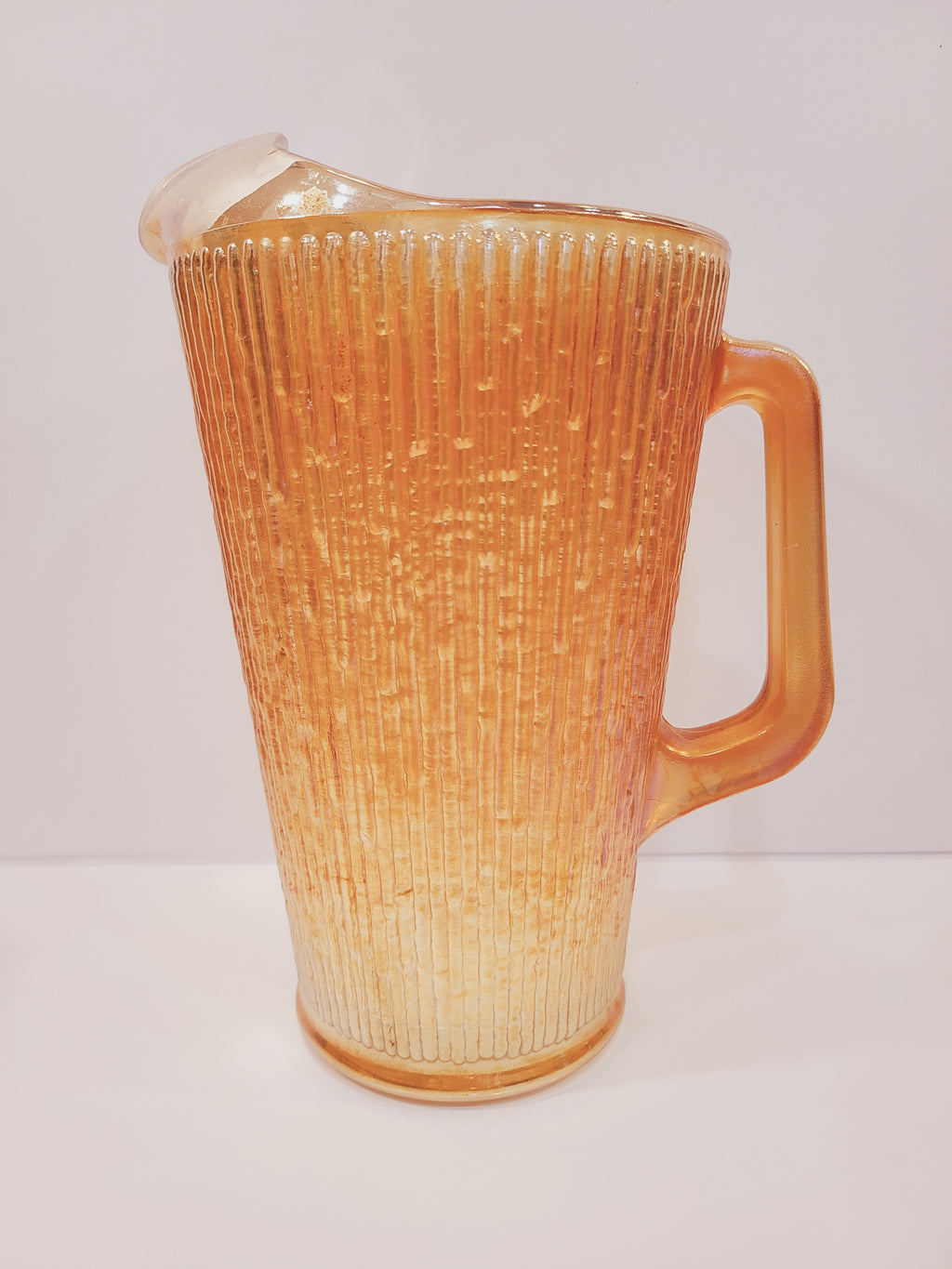 Jeannette Glass Marigold carnival glass pitcher with molded Tree Bark pattern, ice lip spout and pulled handle, Depression-era USA 1920s–1930s, 9 inches tall