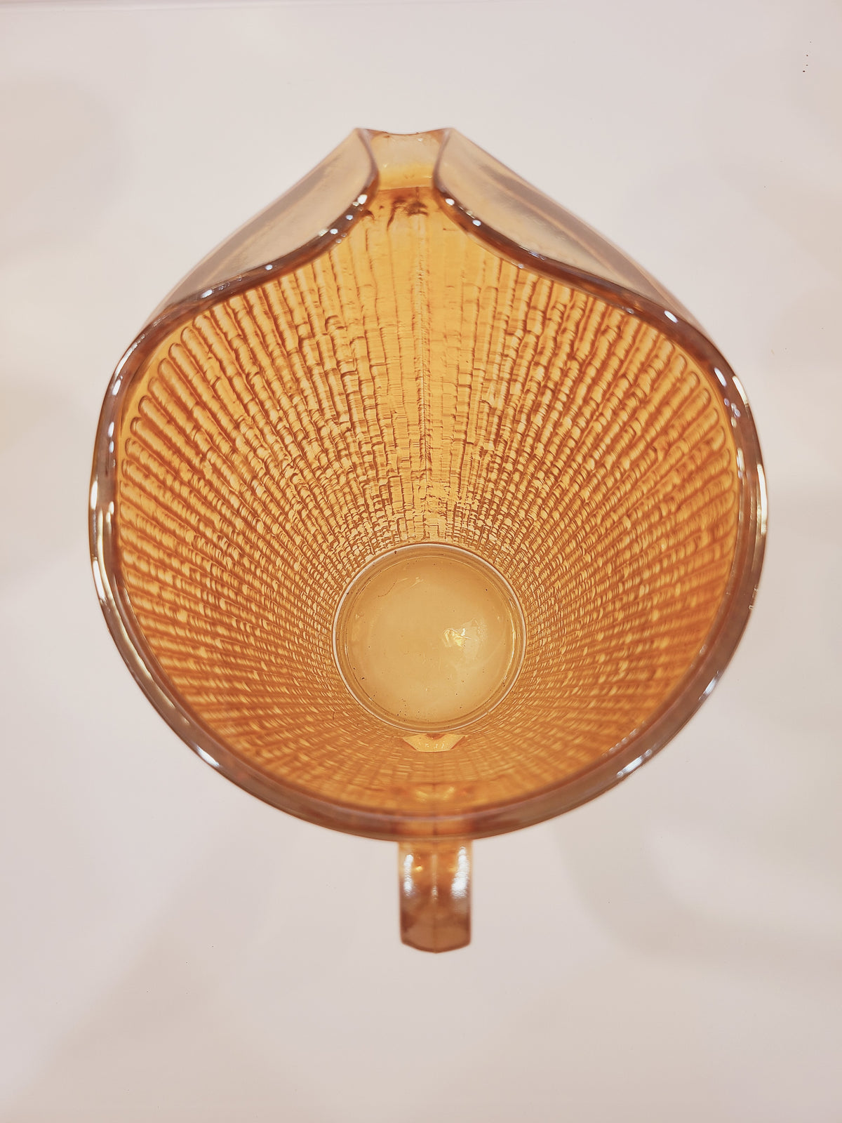 Overhead interior view of Jeannette Glass Marigold carnival glass pitcher showing Tree Bark pattern radiating inward and ice lip spout detail