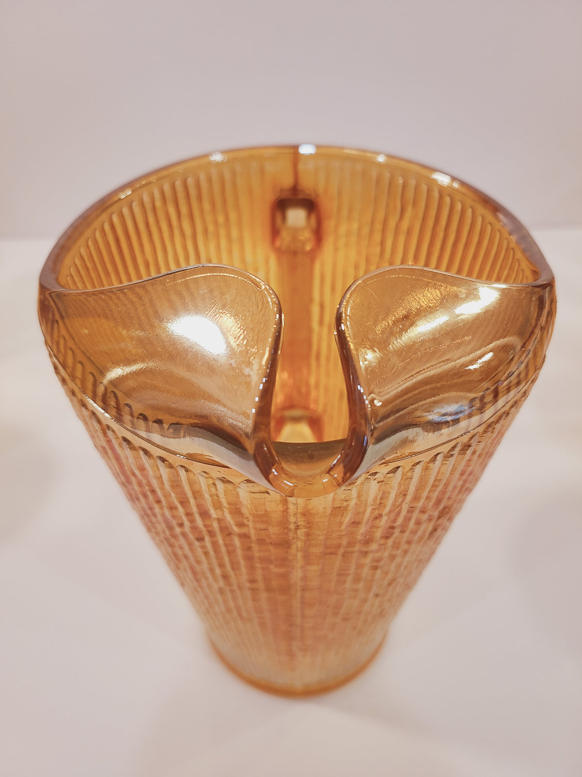Close-up of molded ice lip spout on Depression-era Jeannette Glass Marigold carnival glass pitcher, Tree Bark pattern detail