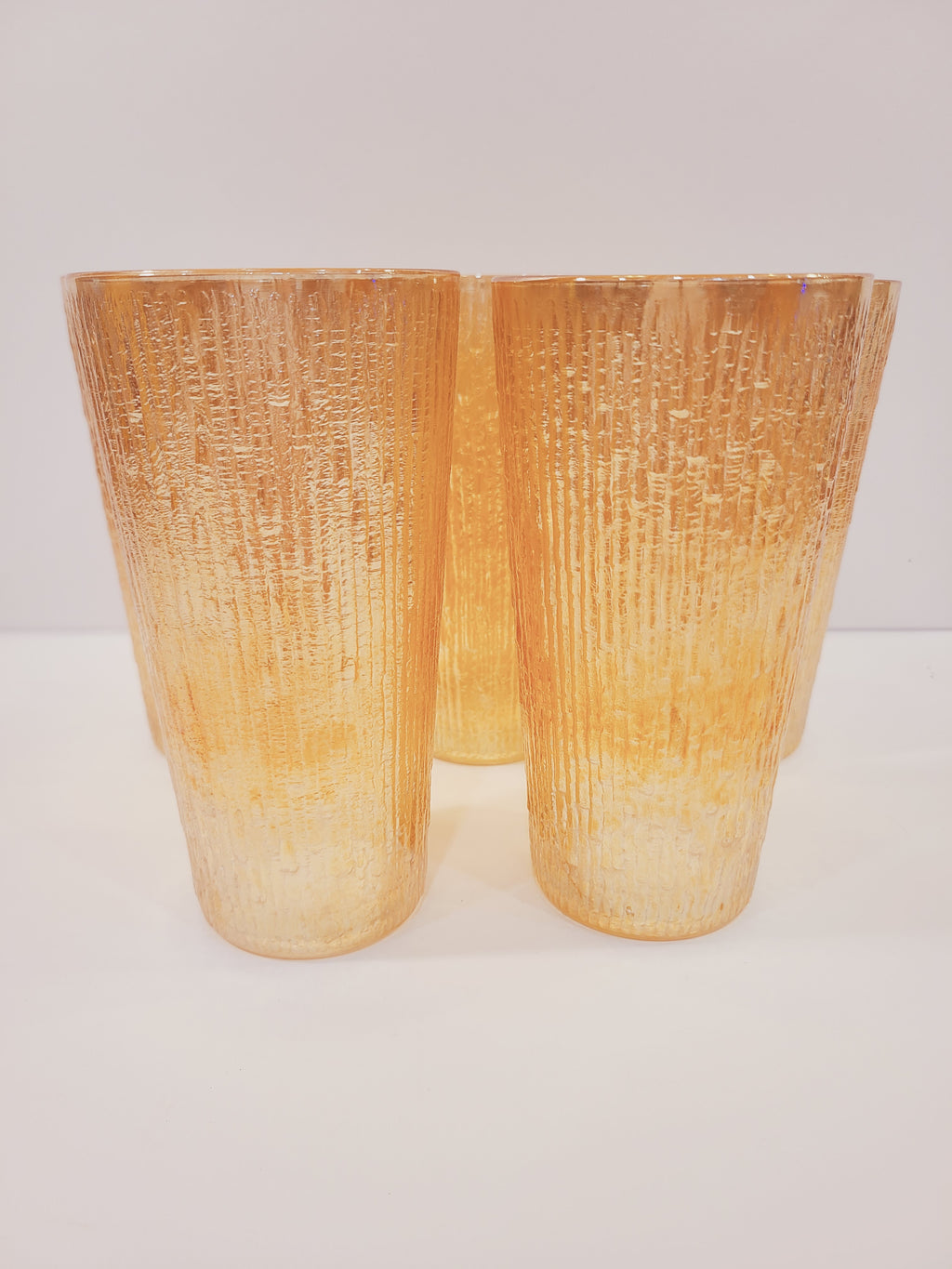 Jeannette Glass Marigold carnival glass tumblers showing deeply molded Tree Bark texture and iridescent metallic luster, Depression-era collectible glassware