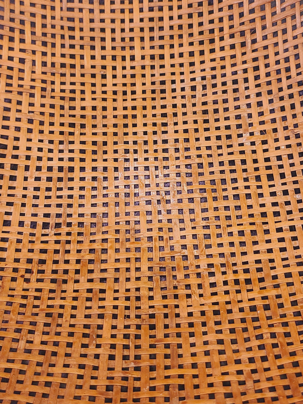 Interior extra close-up of hand-woven split bamboo basket showing aged amber patina and open lattice weave, mid-century East Asian folk craft