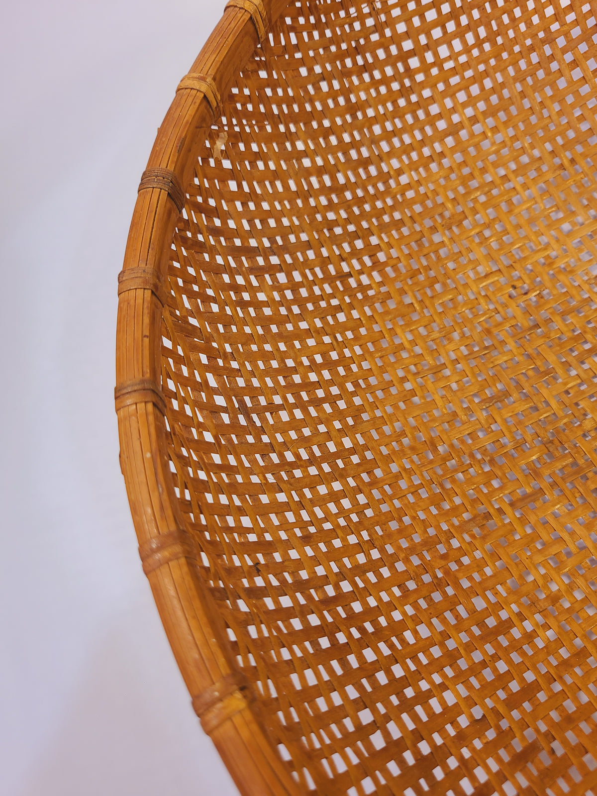 Interior top-down view of vintage bamboo winnowing basket showing open split-bamboo weave and rattan structural frame, circa 1950s–1960s