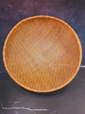 Overhead view of large round hand-woven bamboo winnowing basket on dark surface, 16.5 inch diameter, East Asian vintage folk art