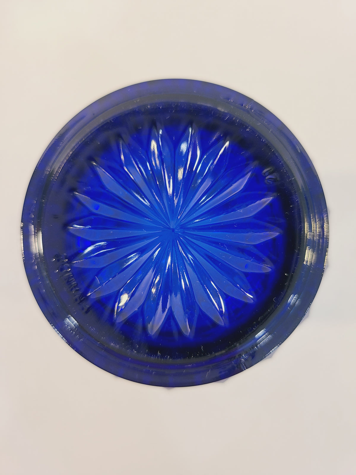Bottom of Avon Royal Sapphire cobalt blue rocks glass base showing light-catching starburst motif — vintageFrance