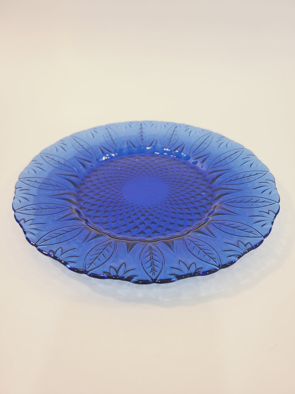 Avon Royal Sapphire cobalt blue glass salad plate, angled view showing embossed leaf rim and diamond-optic texture — France