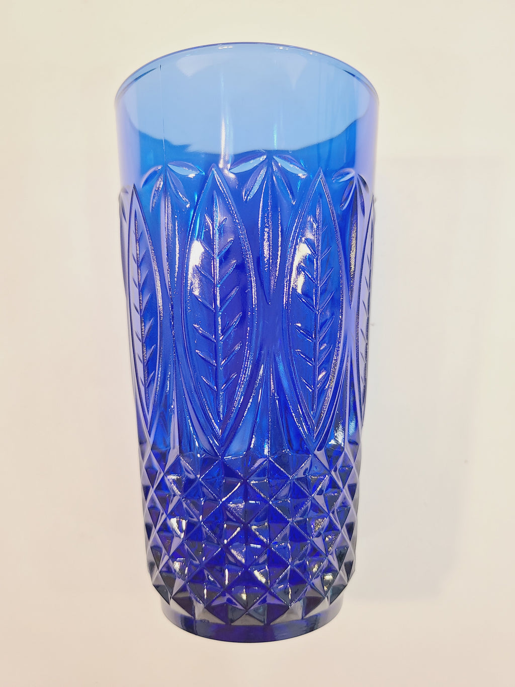 Close-up view of Avon Royal Sapphire cobalt blue highball glass showing embossed leaf pattern and diamond-optic base — France