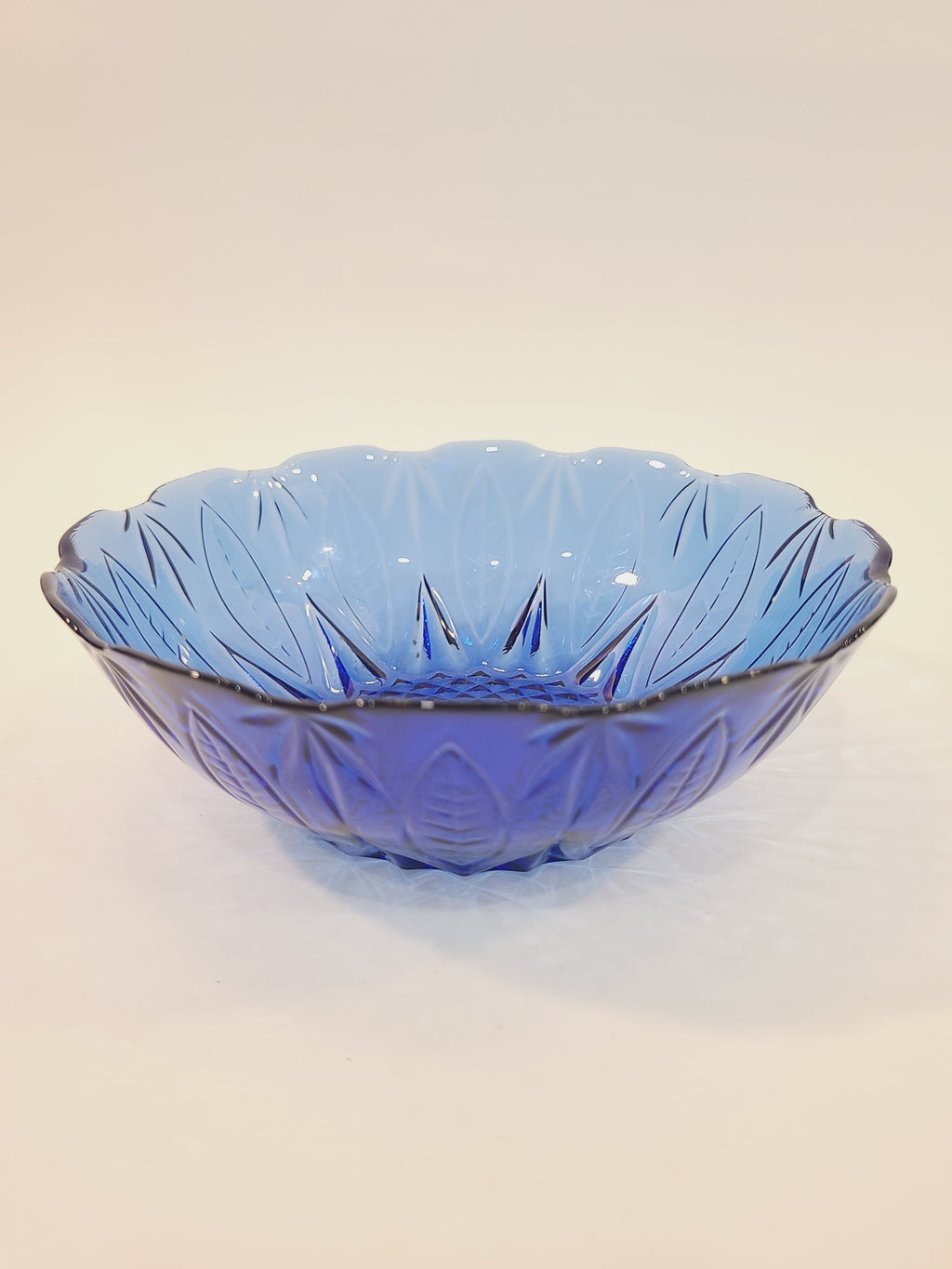 Avon Royal Sapphire cobalt blue glass cereal bowl, side-angle view showing scalloped rim and embossed leaf pattern — vintage France