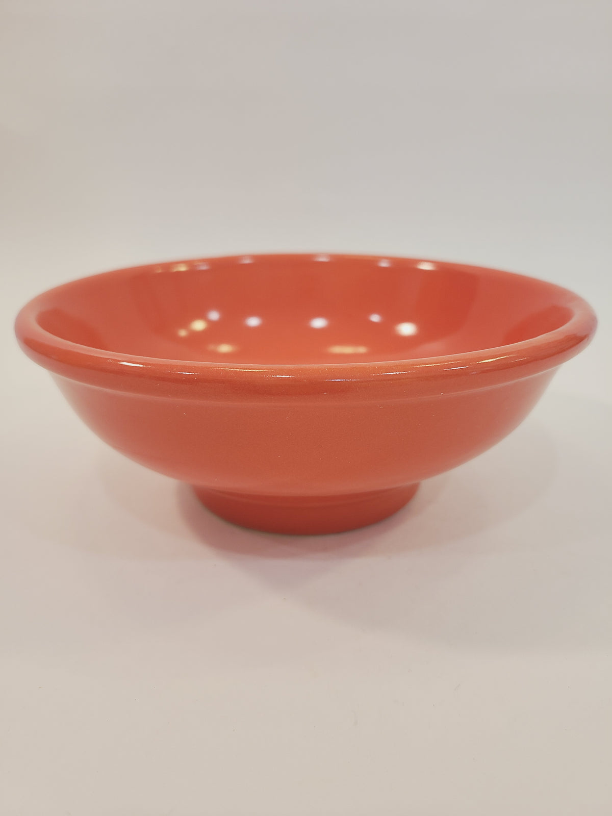 Mid-century American coral glaze utility bowl with rolled rim, full view — 1940s–1950s USA stamped ceramic kitchenware
