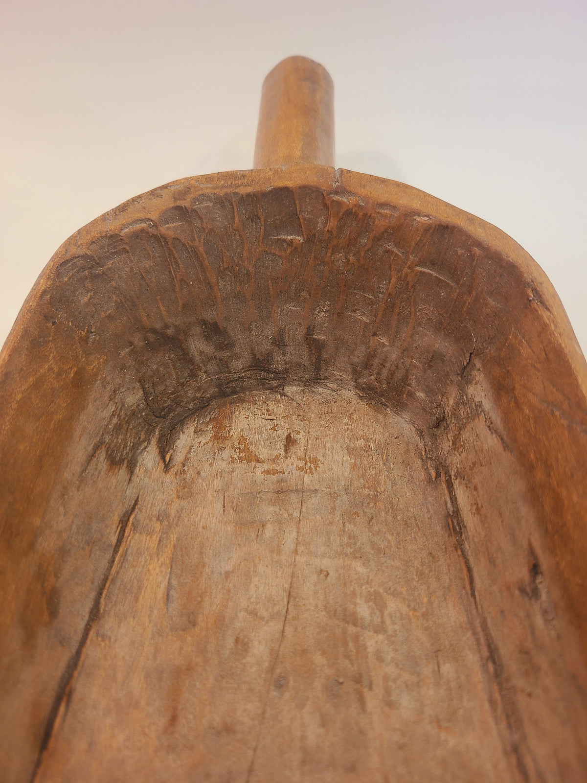 Interior of antique hand-carved hardwood grain scoop showing visible gouge and chisel tool marks — primitive treenware
