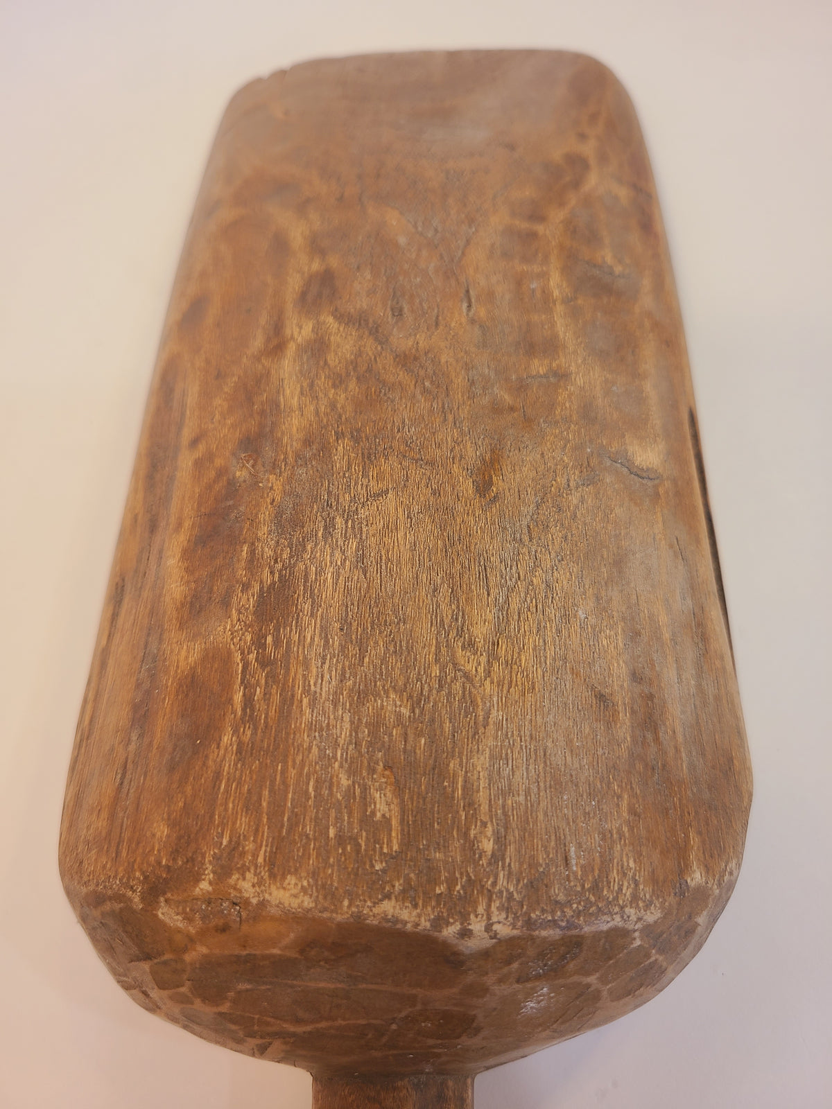 Underside of antique hand-carved hardwood grain scoop showing hand-chiseled gouge marks and rich wood grain patina