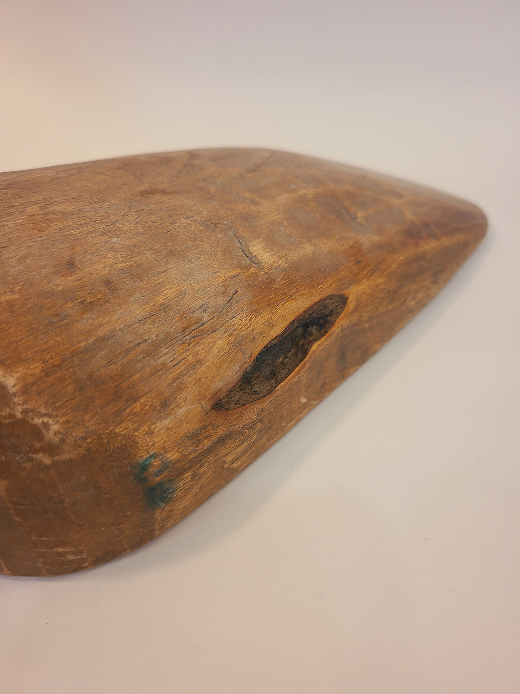 Close-up of antique hardwood grain scoop showing natural crevice in wood and aged honey-brown patina