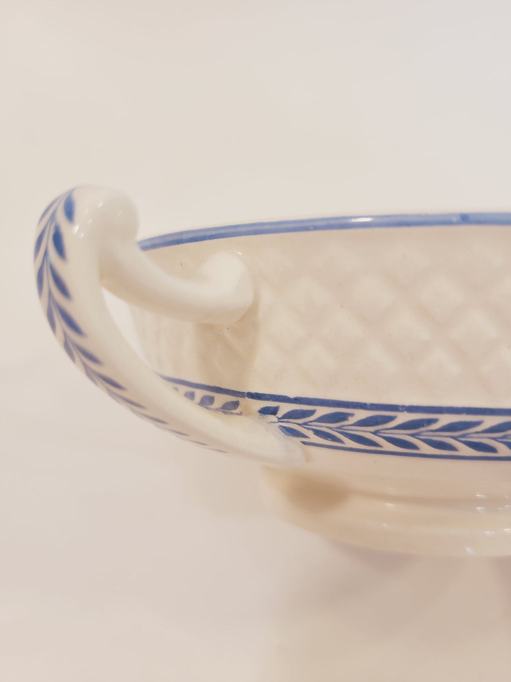 Close-up of Copeland Spode Elaine Mansard cream soup bowl handle showing soft blue laurel vine and embossed diamond texture