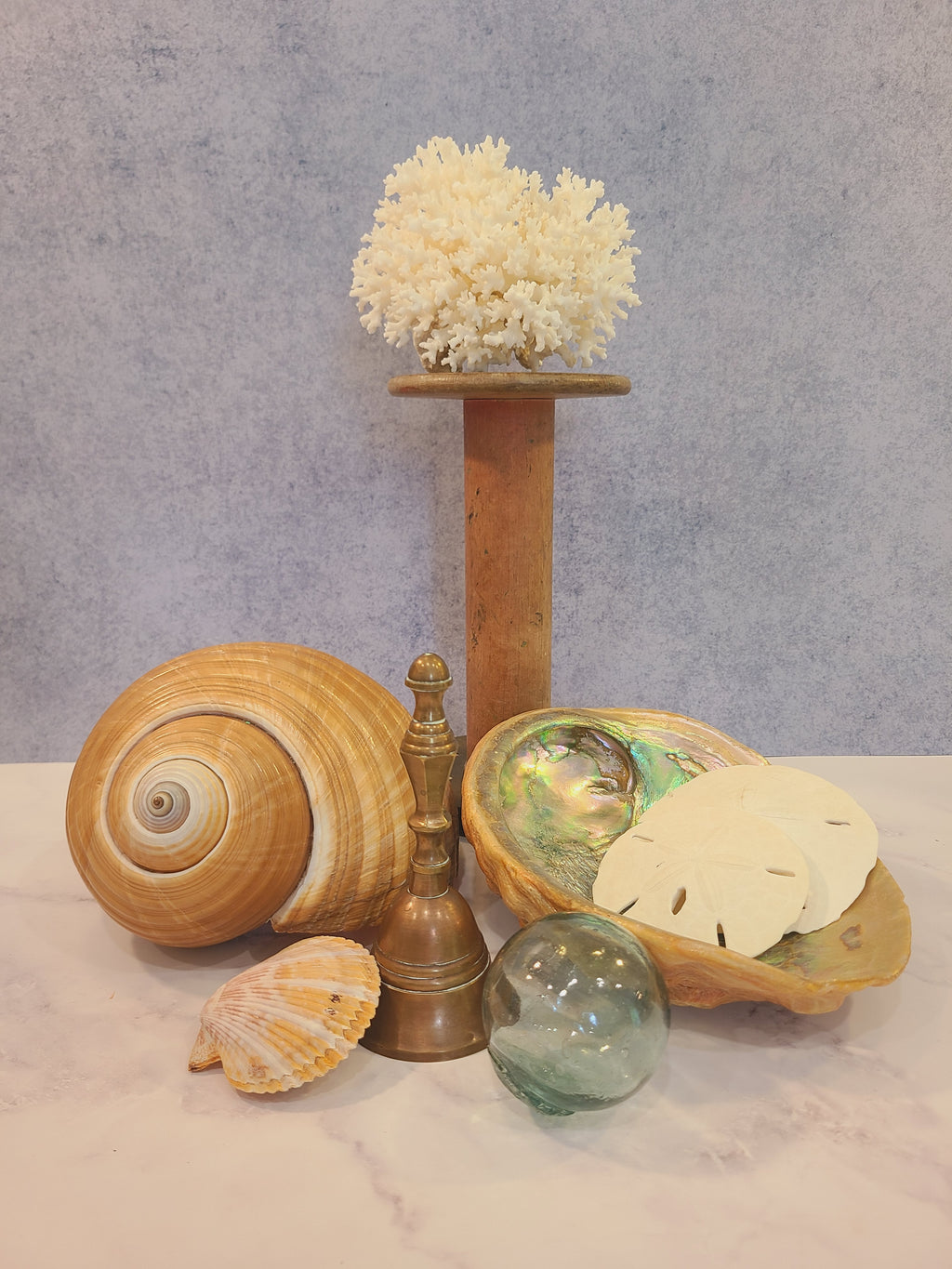Vintage solid red brass hand bell styled in coastal vignette with shells, abalone, sea glass float, and coral — coastal decor