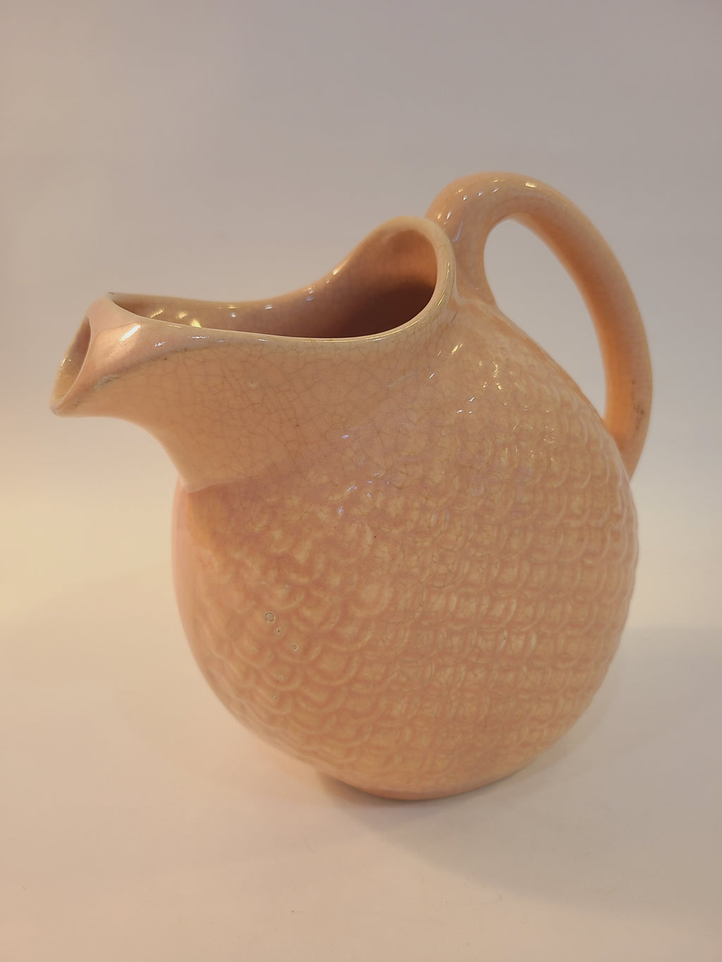 Hull Pottery Nuline Bak-Serve pitcher spout side view, blush pink fish scale ceramic, round body with ice-catcher spout, vintage 1930s kitchenware