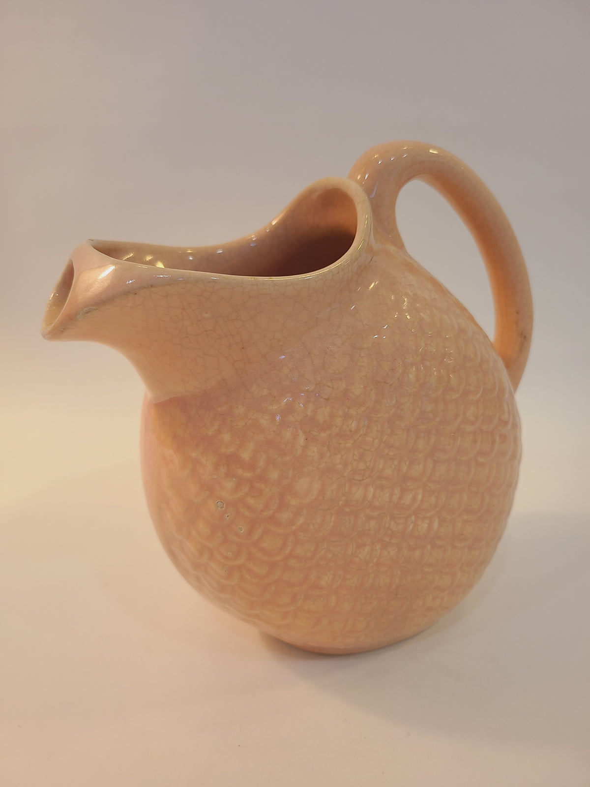 Hull Pottery Nuline Bak-Serve pitcher spout side view, blush pink fish scale ceramic, round body with ice-catcher spout, vintage 1930s kitchenware