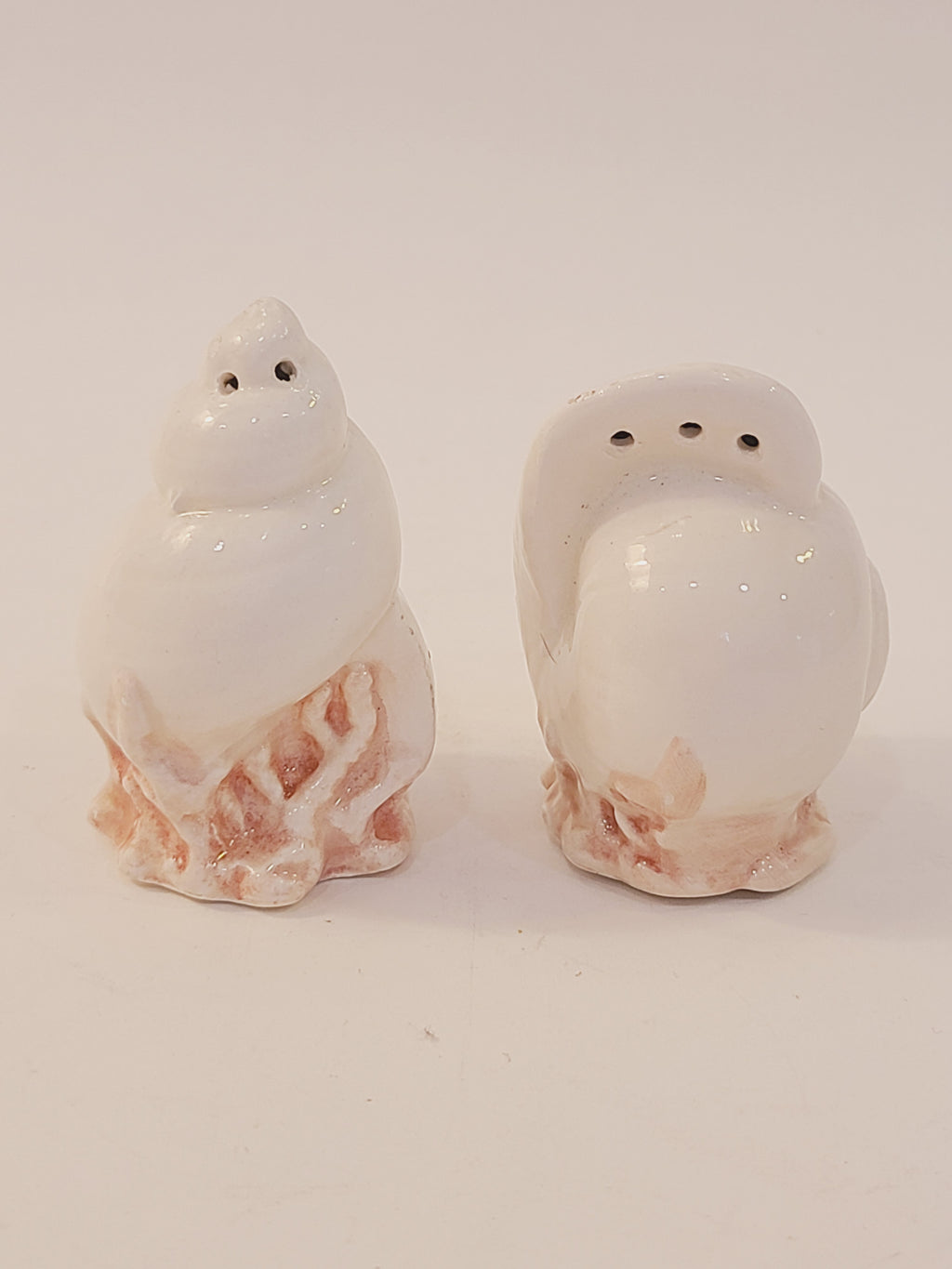 Fitz and Floyd Coquille seashell salt and pepper shaker set, white ceramic moon snail and conch shell forms on pink coral bases, vintage 1970s–1980s coastal decor