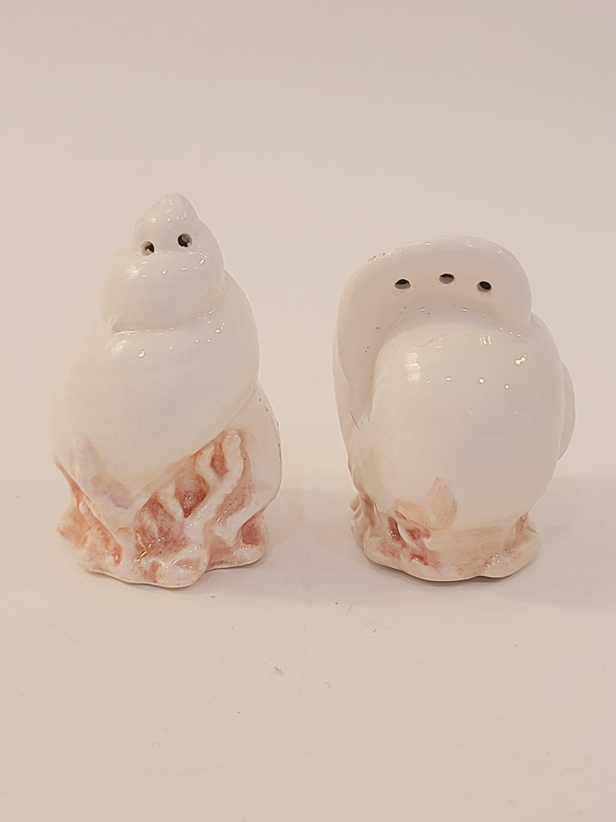 Fitz and Floyd Coquille seashell salt and pepper shaker set, white ceramic moon snail and conch shell forms on pink coral bases, vintage 1970s–1980s coastal decor