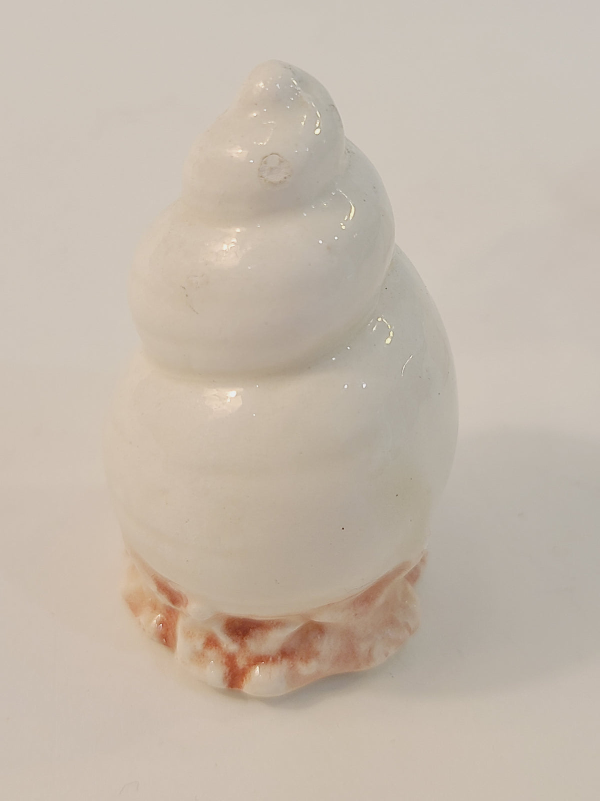 Fitz and Floyd Coquille moon snail ceramic salt shaker close-up, glossy white spiral shell form on pink coral base, vintage coastal kitchenware made in Japan