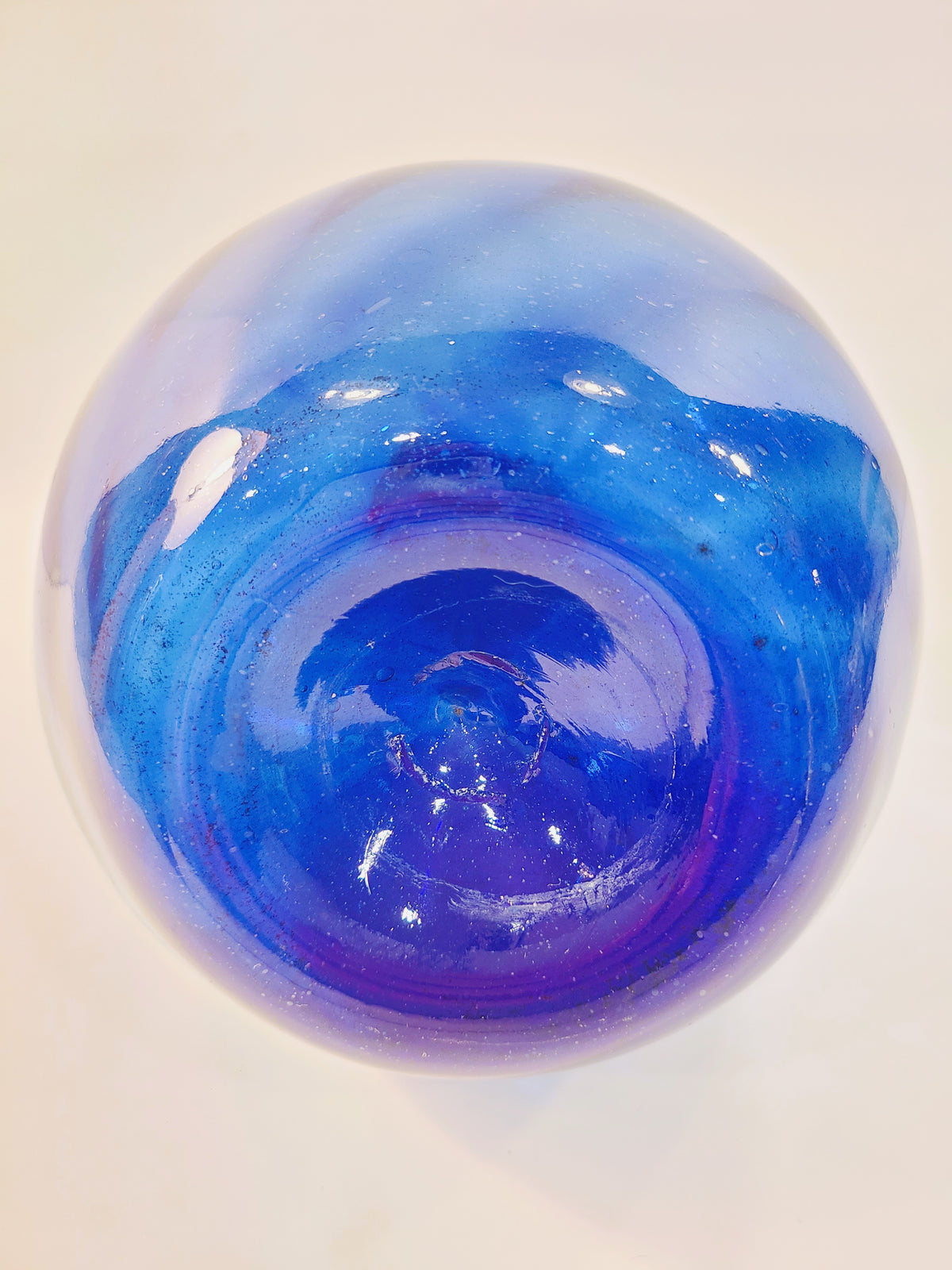 Bottom view of a cobalt blue glass onion bottle showing its thick glass base and pontil mark