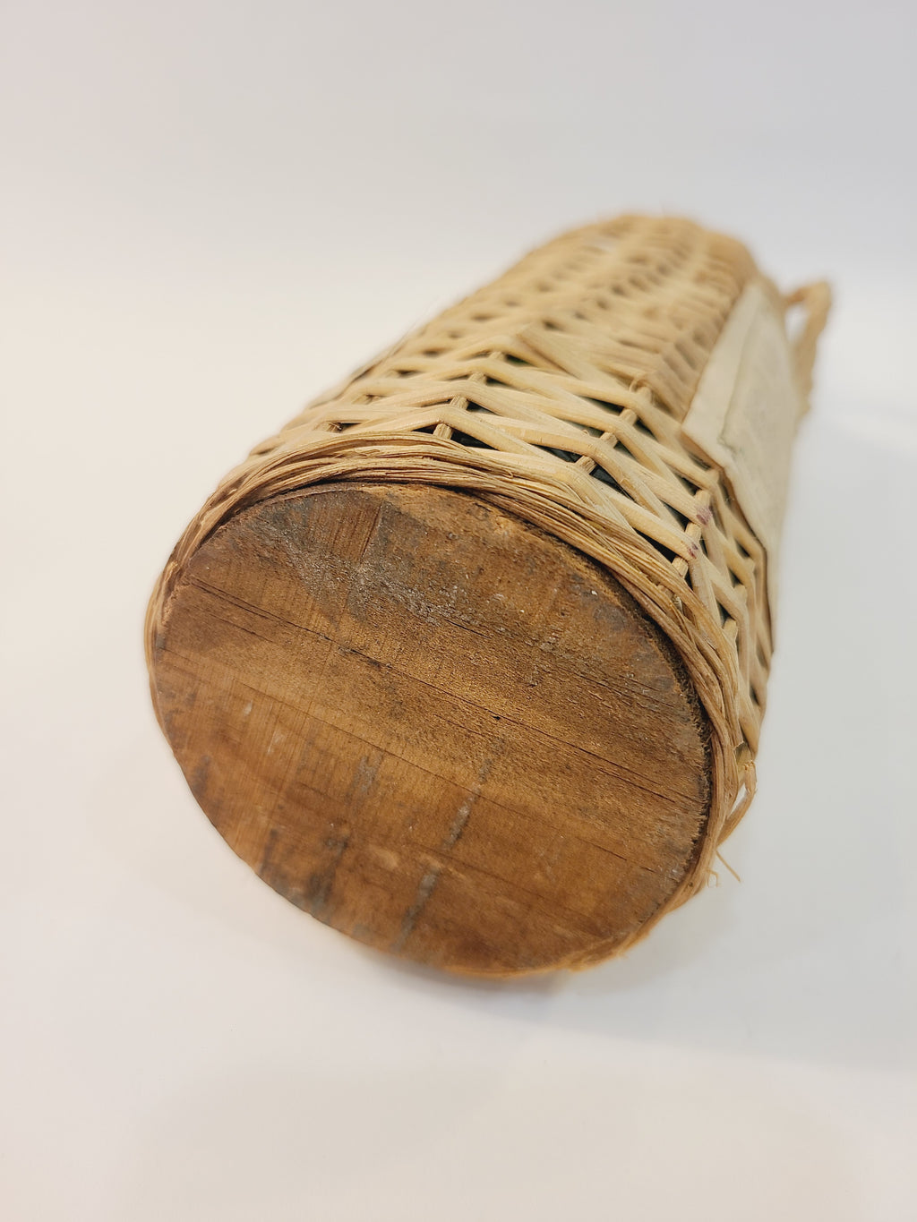 Close-up of wooden bottom of wicker rattan Roncoco rum bottle