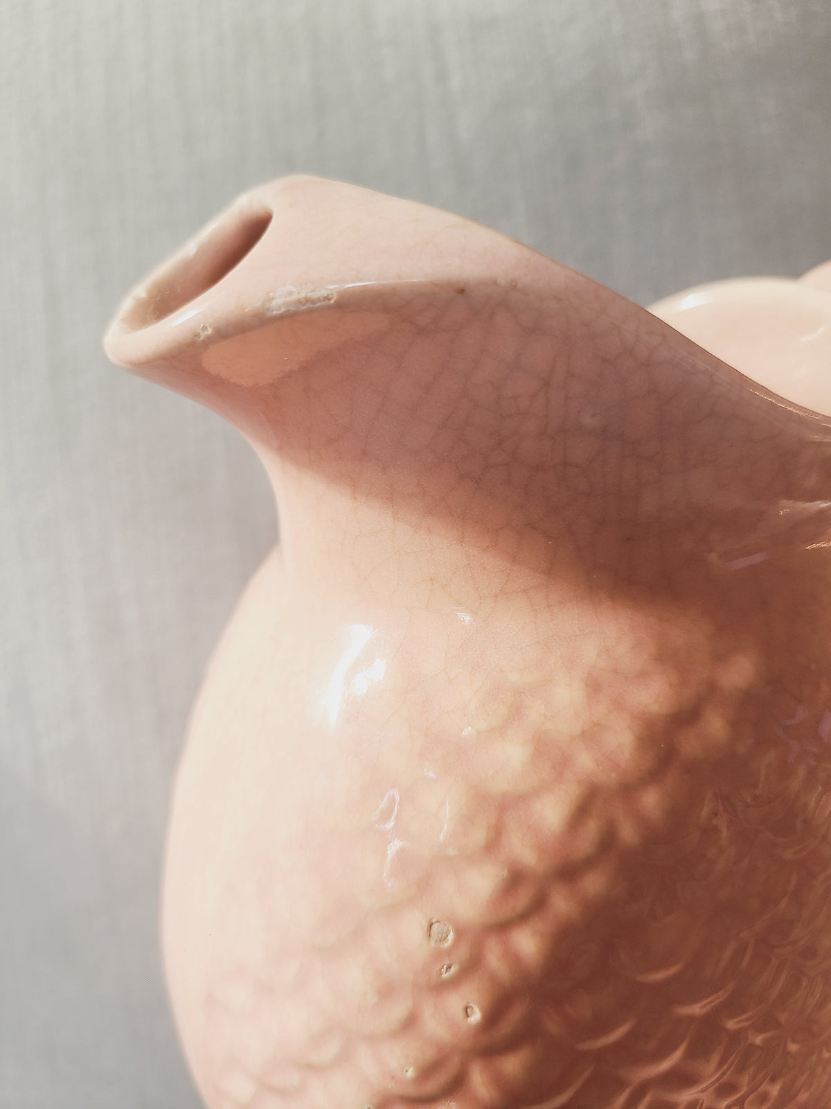 Close-up of Hull Pottery Nuline pitcher spout showing minor glaze chip and ice-catcher lip, blush pink ceramic, condition detail
