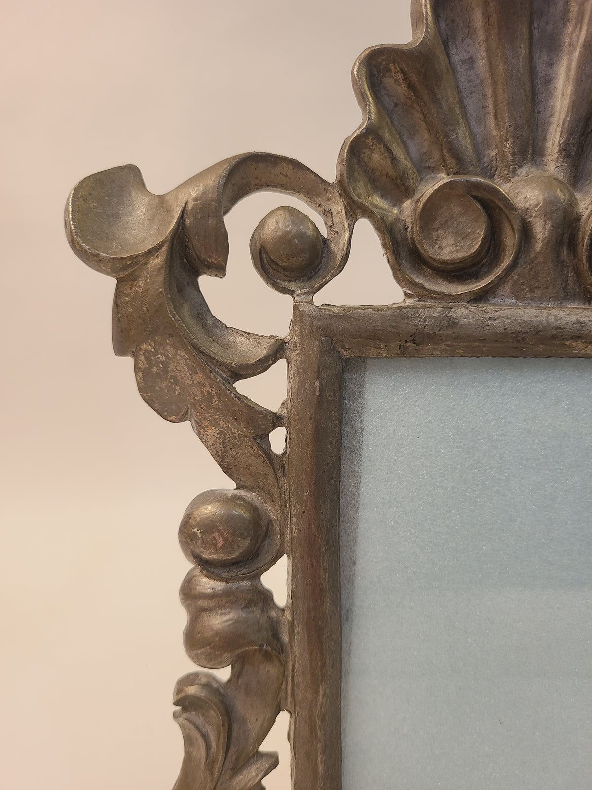 Close-up of upper corner scrolling acanthus leaf and ball detail on vintage Rococo Revival cast alloy picture frame