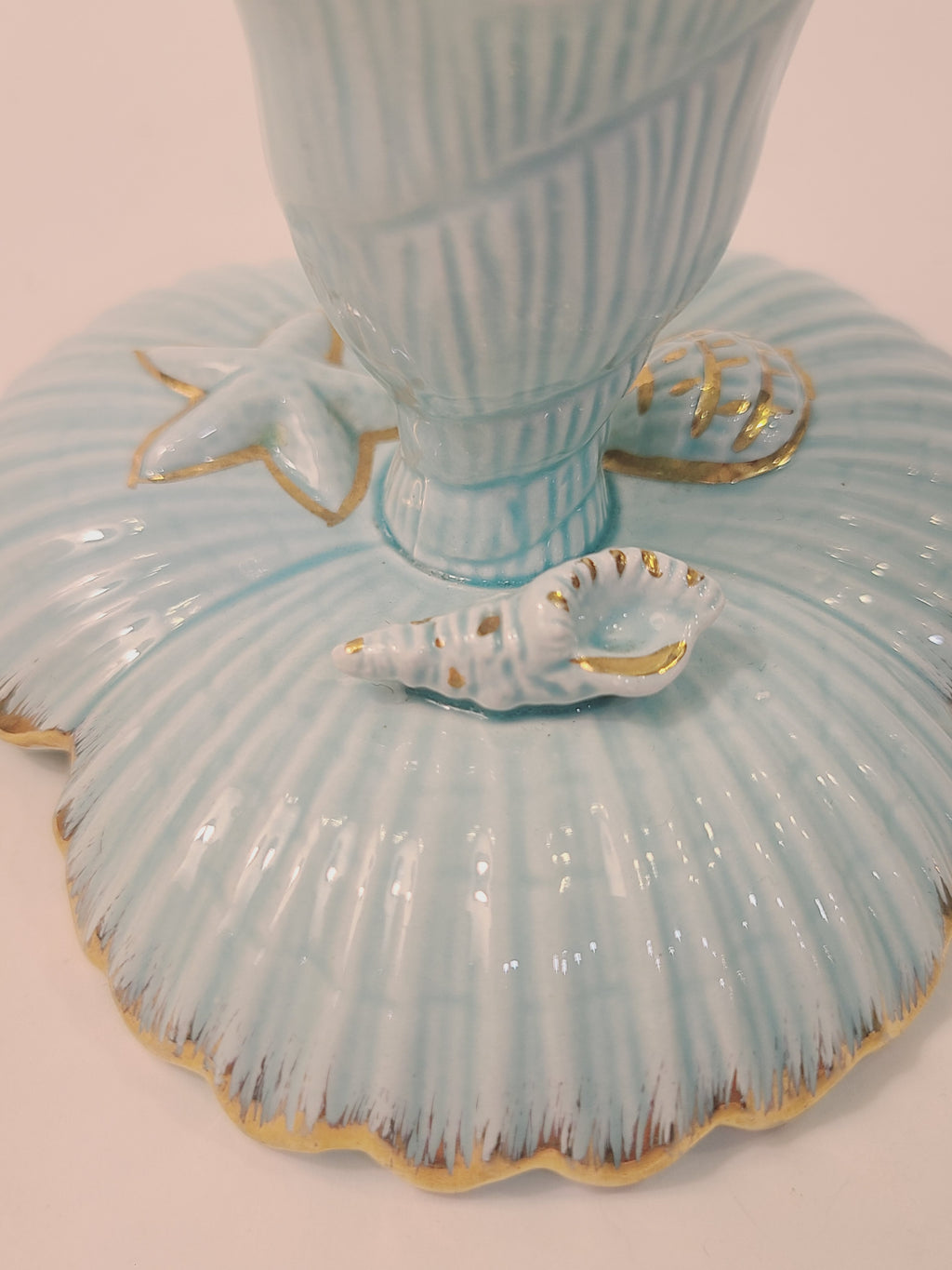 Close-up of NAPCO Tropic Sea candle holder base with hand-painted gold starfish, conch shell, and clam shell ceramic accents